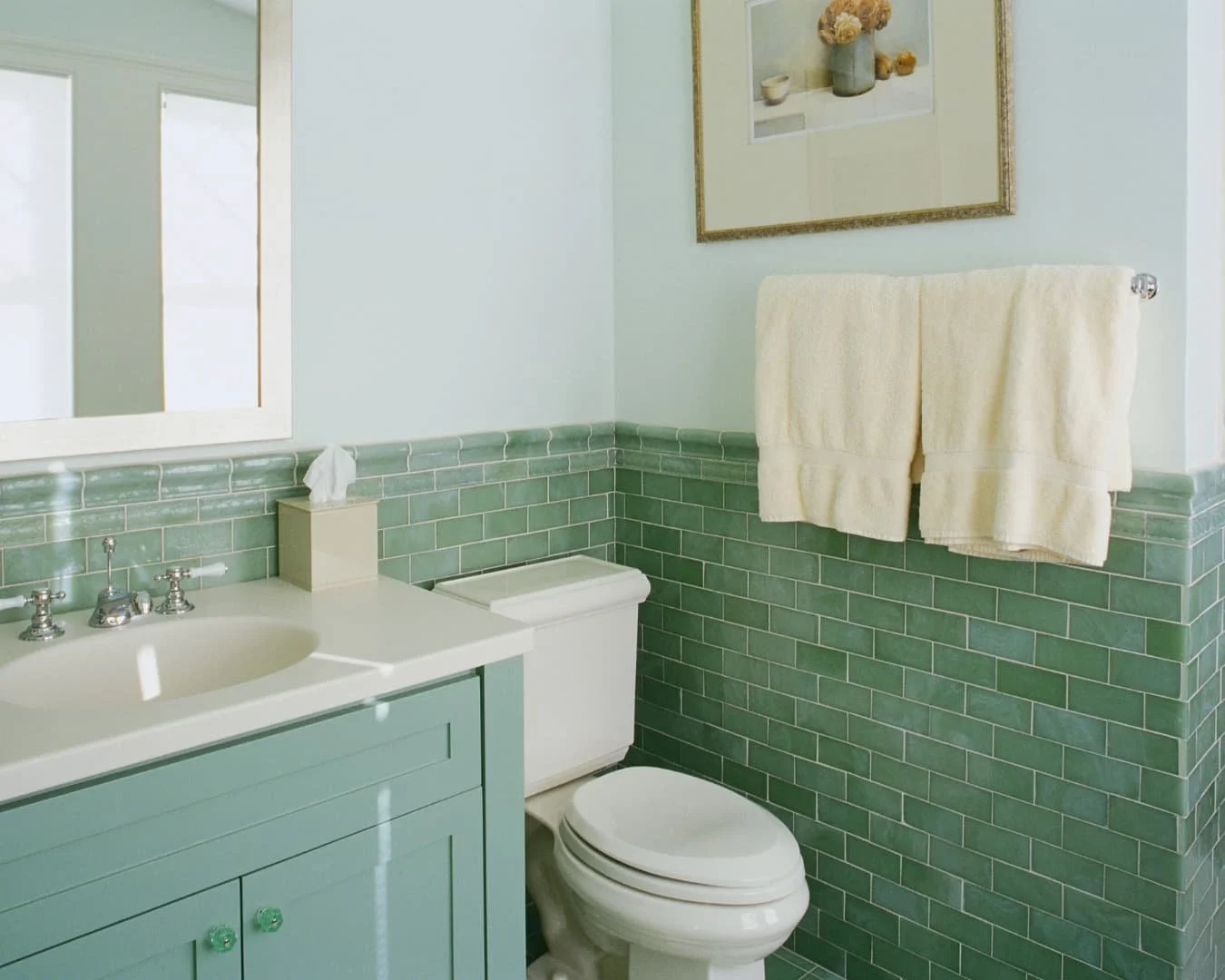 Bathroom inspiration with a soft green vanity, light countertop, and fresh updated layout.