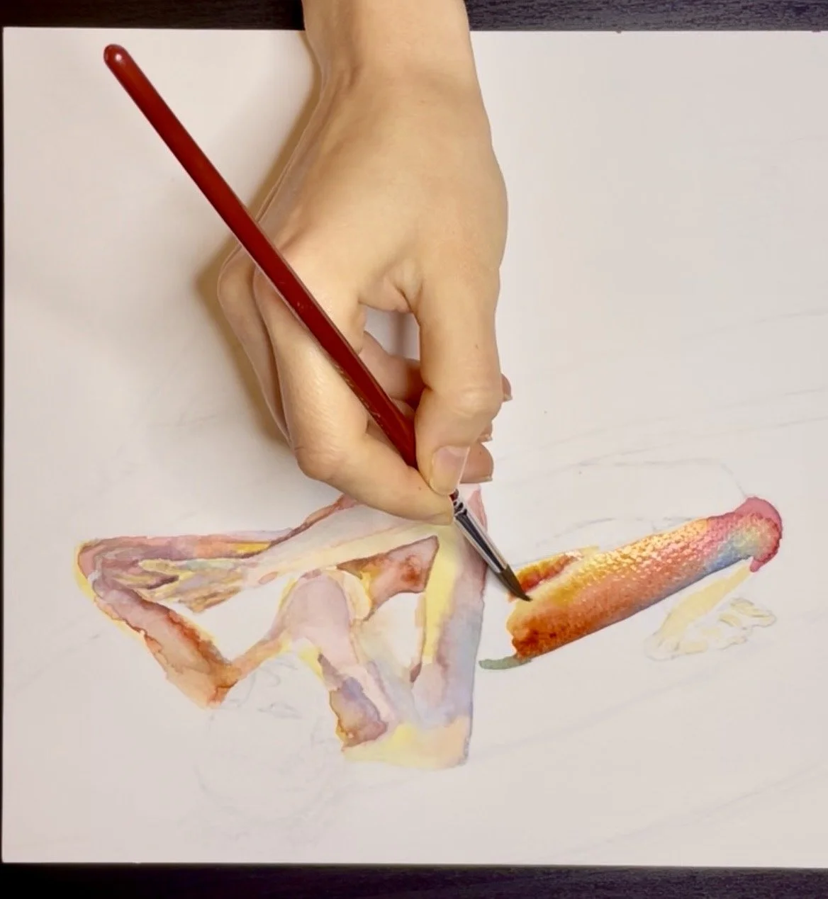 A person is painting a watercolor illustration of a woman on white paper, using a fine brush.