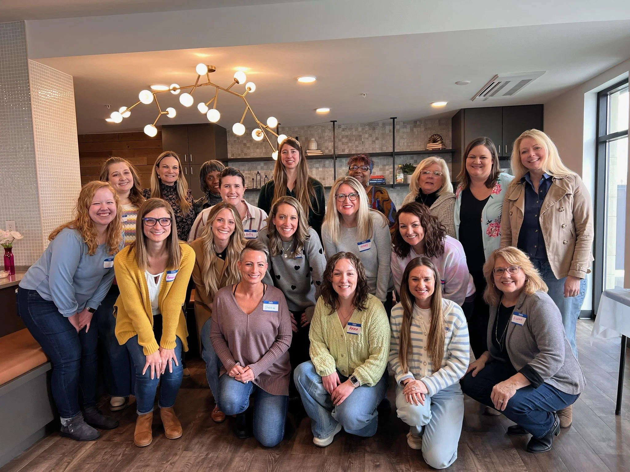 Group of women posing for a photo in a modern, well-lit indoor space.