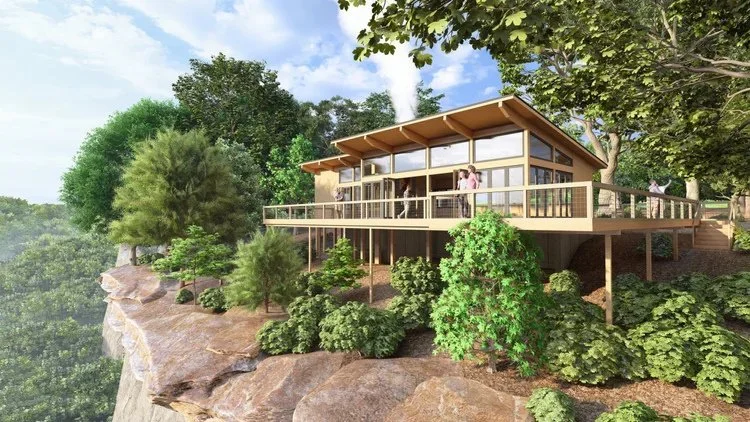 Modern house with large windows on a cliffside, surrounded by trees and greenery.