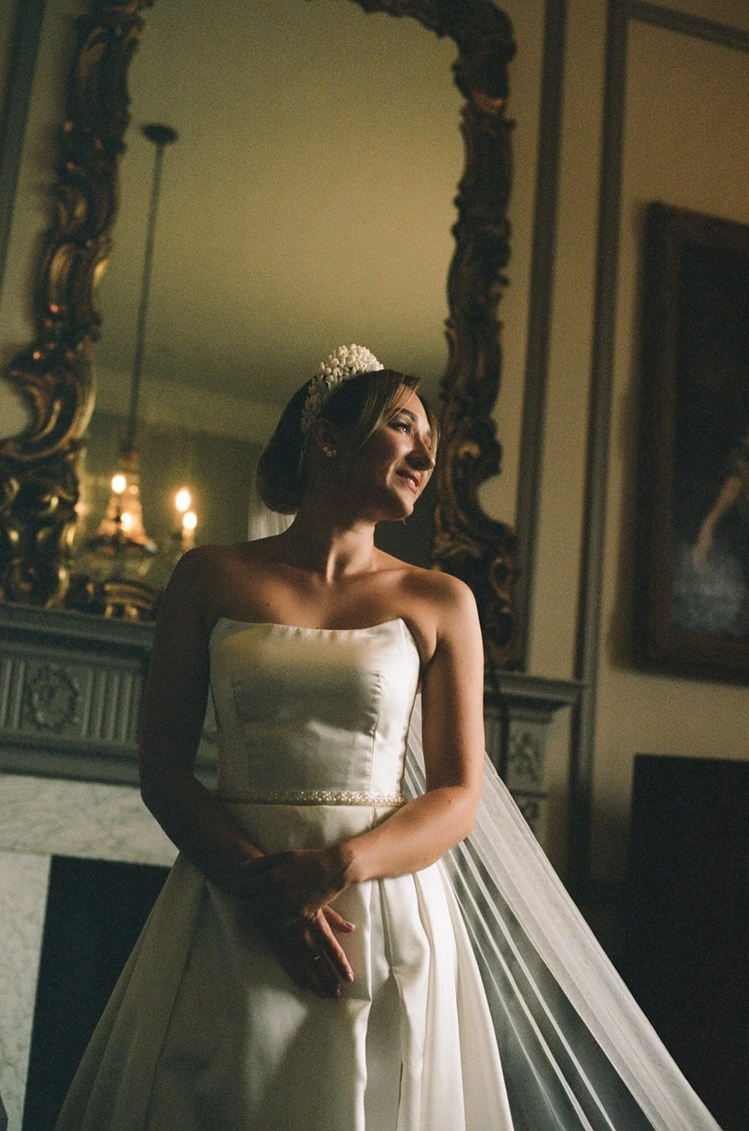 Bride stands in front of fireplace at grand estate wedding in Scotland