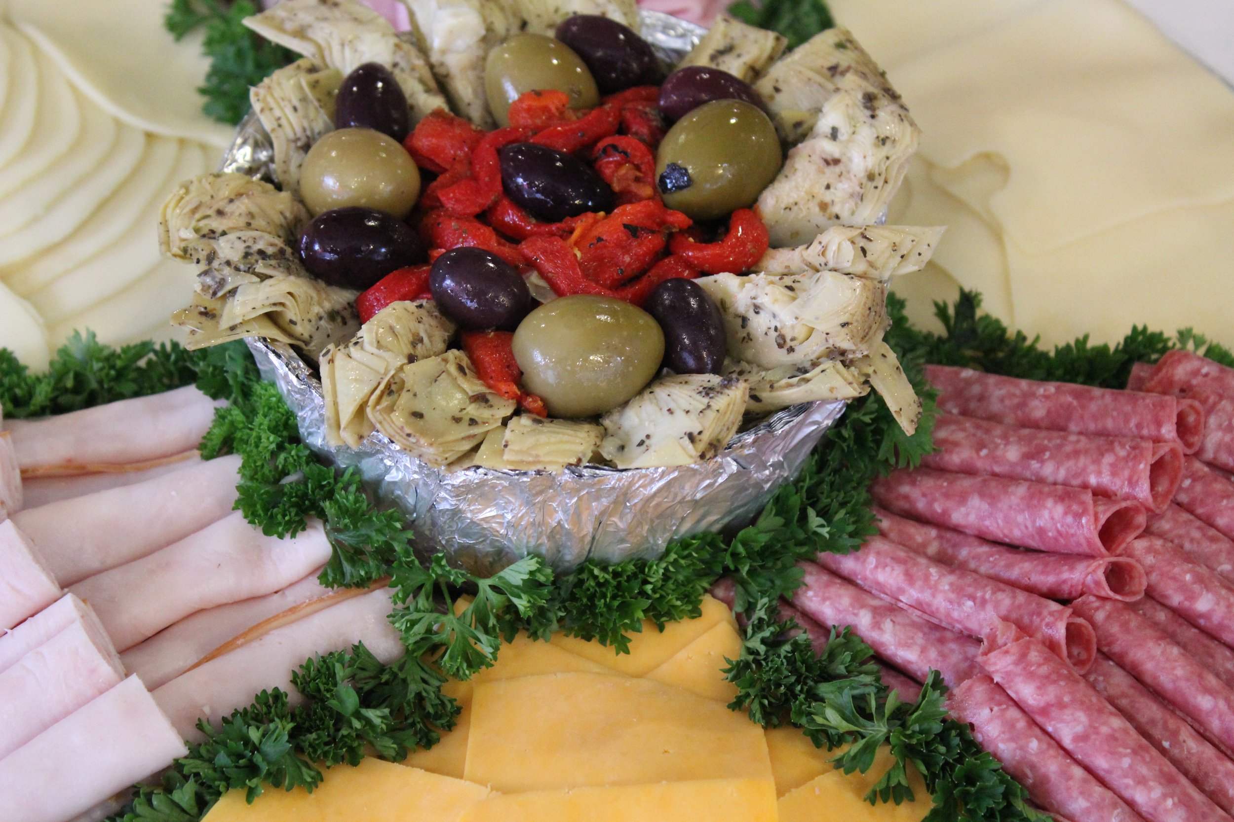 Elevate your next event with a gourmet antipasto and cold cut platter. This vibrant display includes hand-rolled deli meats, assorted cheeses, and a Mediterranean medley of olives, artichokes, and roasted peppers.