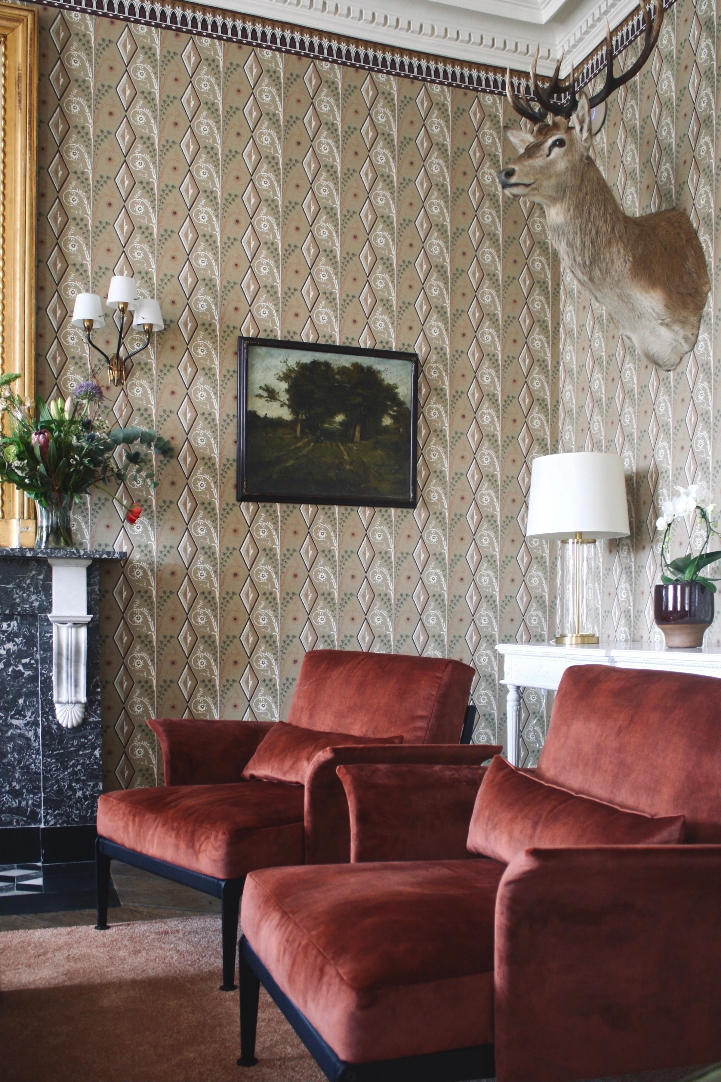 Living room detail in warm colours and historic wallpaper