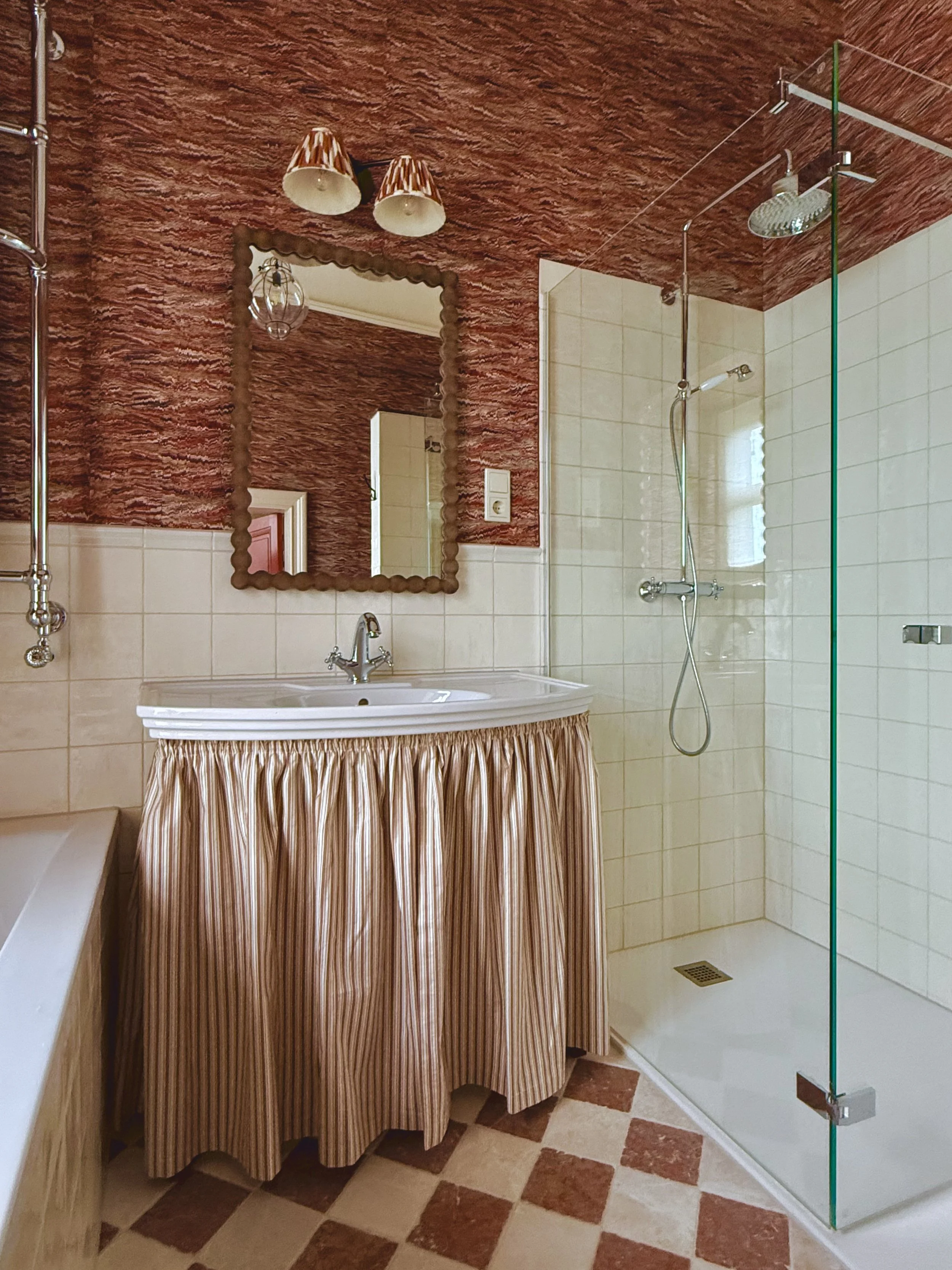 Bathroom in red tones and patterns with skirted sink