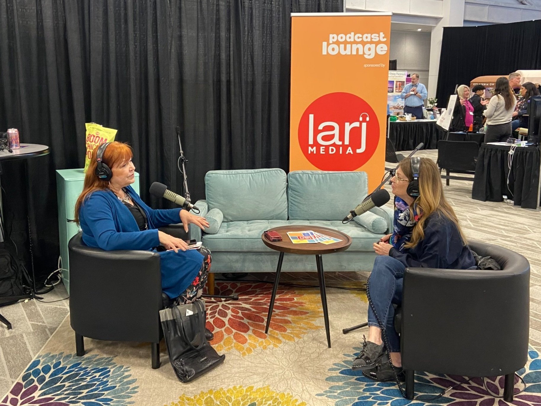 Tina Nole interviews Kate Becker in a makeshift living room or "Podcast Lounge" at the Northwest Events Show