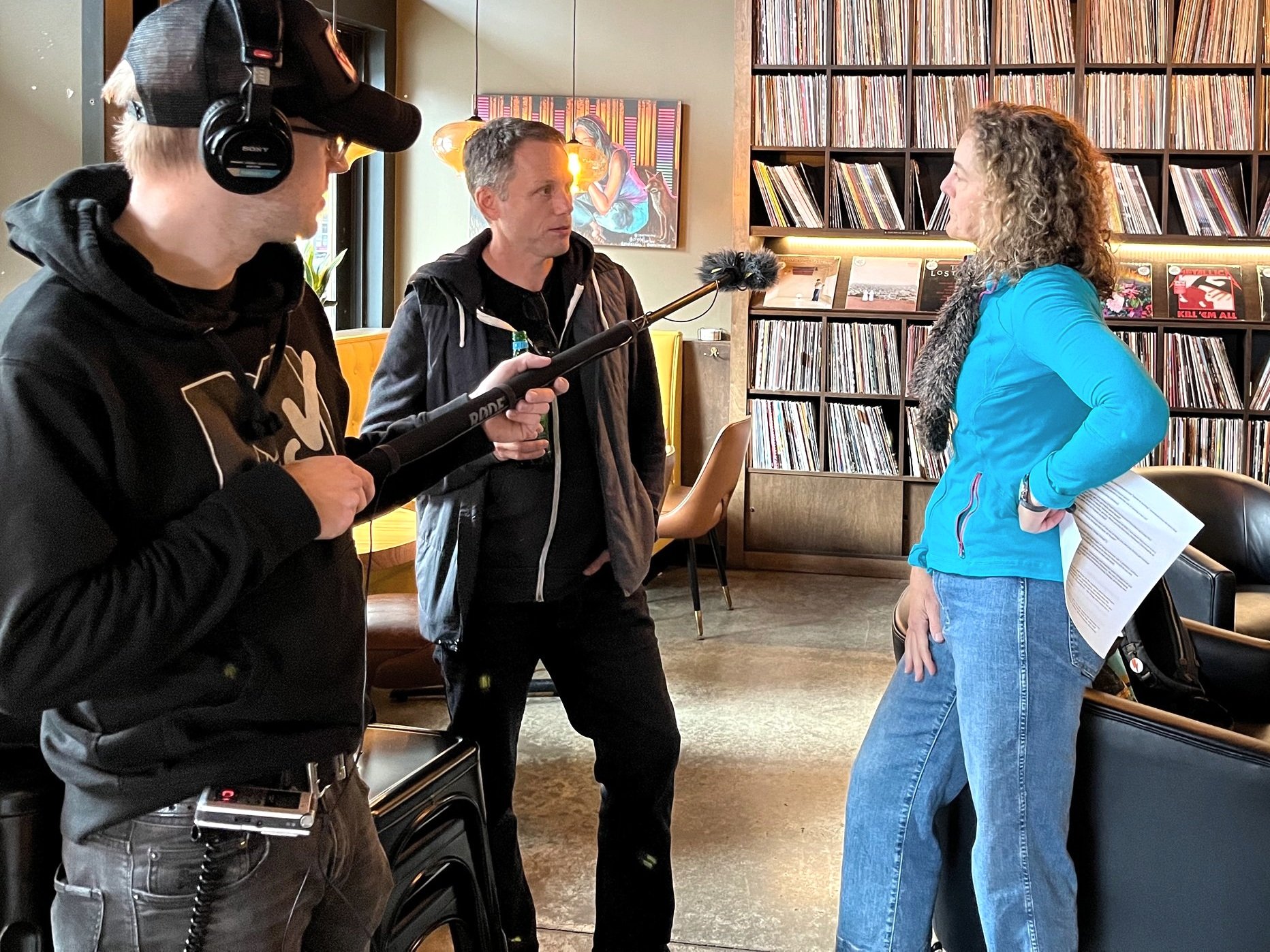 Sound operator hold boom mic to record and interview between John Richards and Andrea Learned