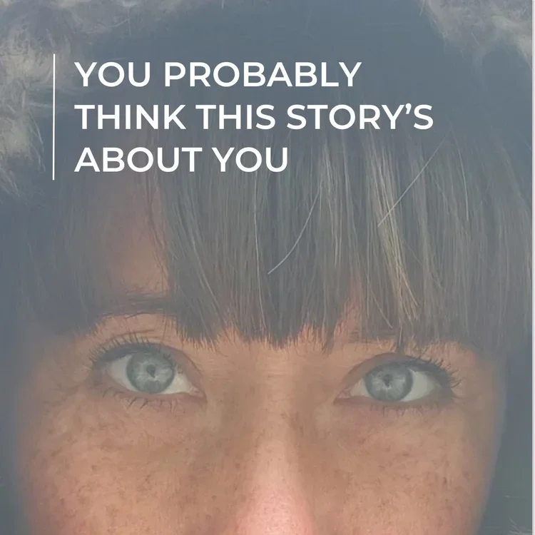 Close-up of a woman with blue eyes and dark brown hair with bangs, and freckles on her face, with text overlay that reads 'You probably think this story's about you.'