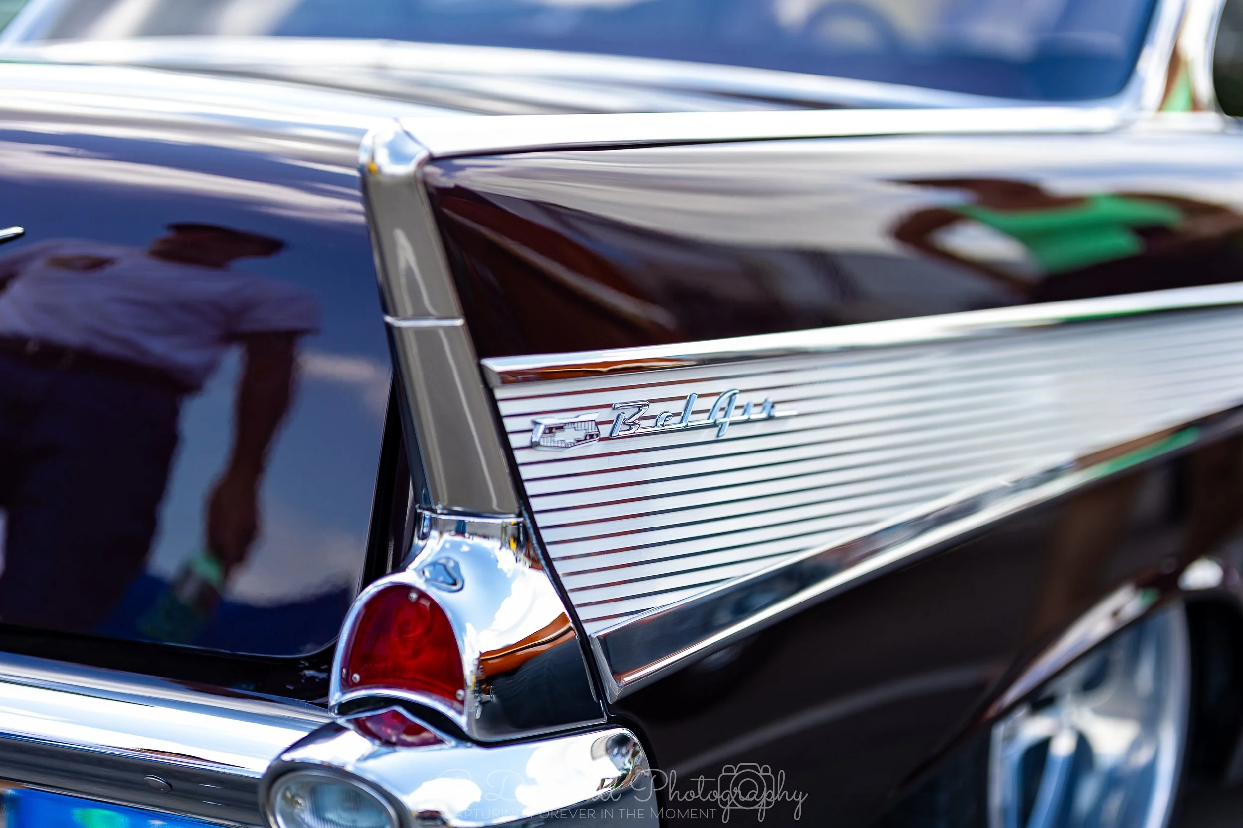 Close-up of the rear end of a black classic Cadillac car, showing the tail light, chrome trim, and a badge that reads 'Biar' on the side.