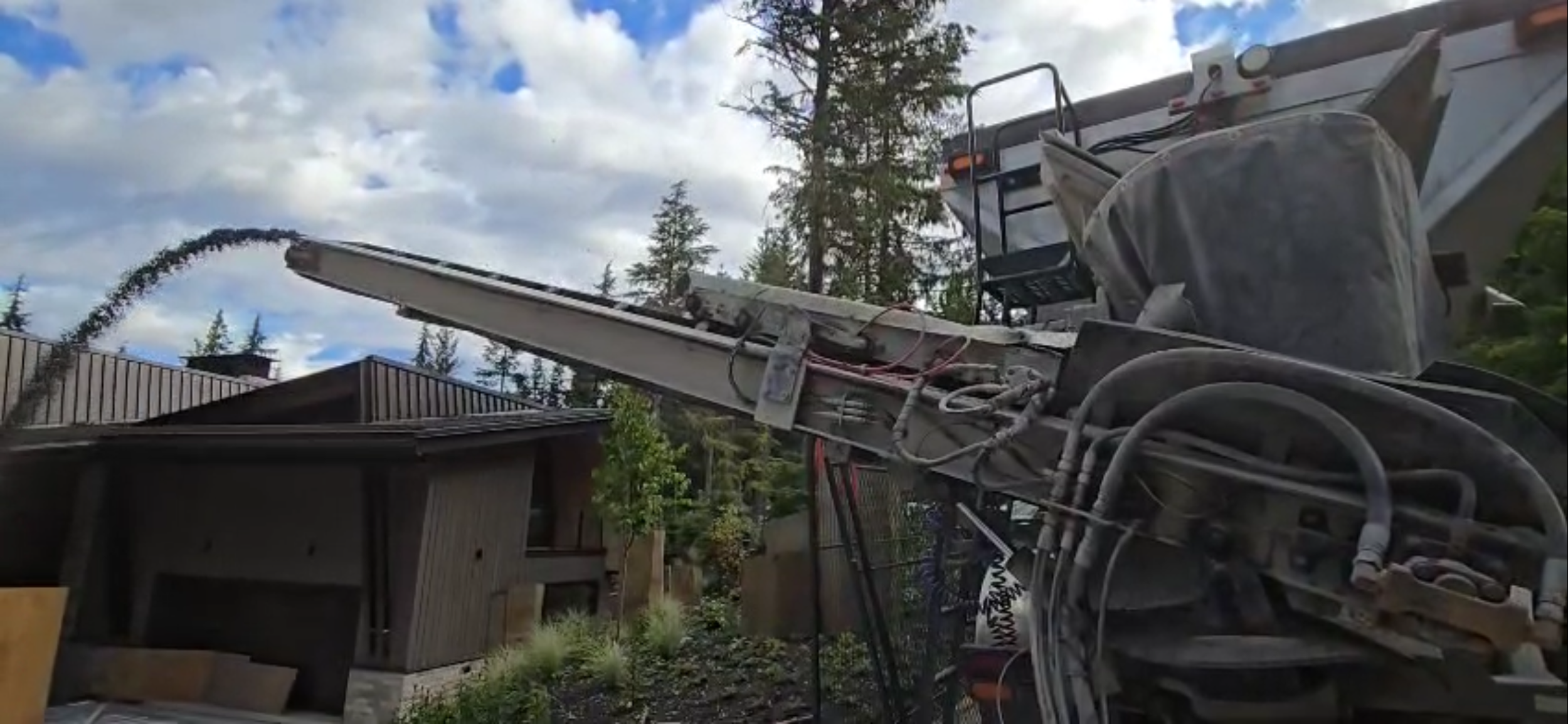 Slinger truck unloading aggregate for driveway build.
