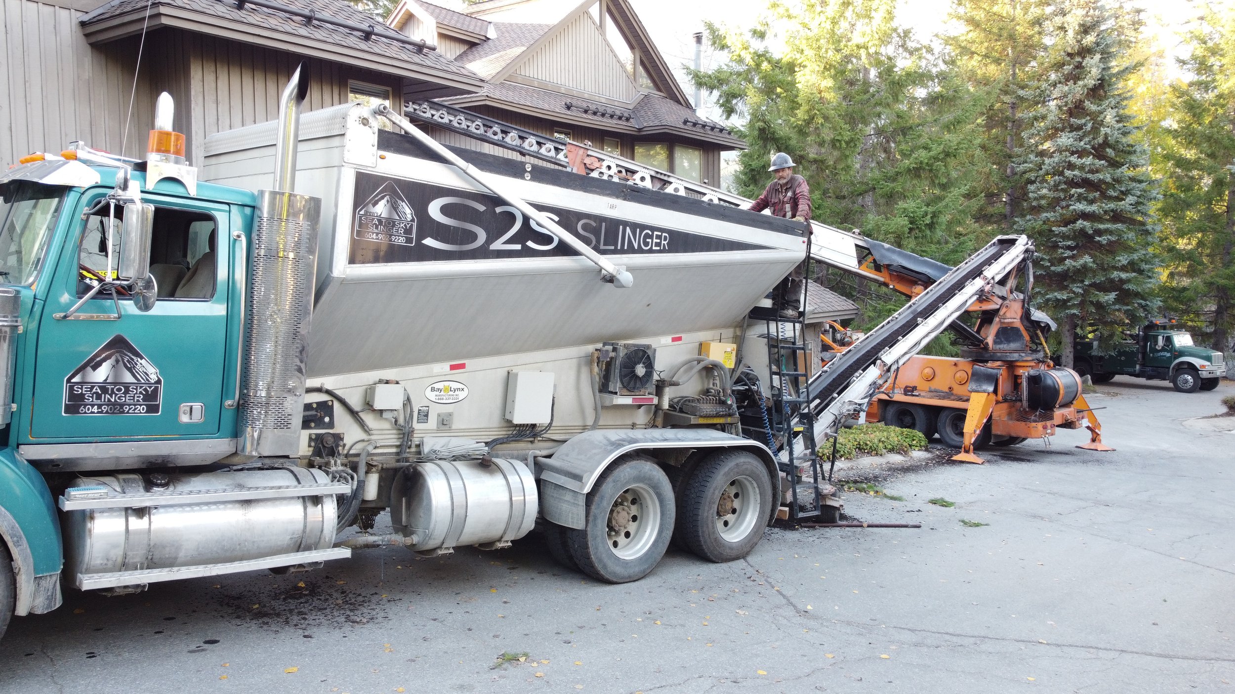 Telebelt delivering soil to backyard with tight access in Whistler