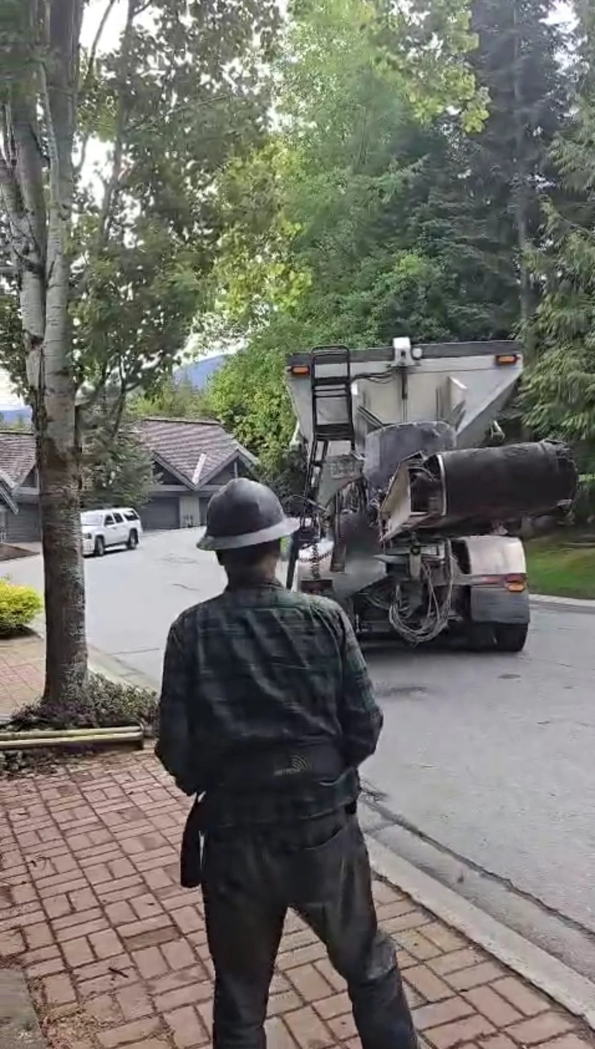 Slinger truck operator using ground control to reverse truck towards aggregate placement area.