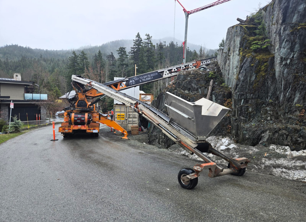 Telebelt conveyor truck being set-up and reaching into construction site for backfill delivery.