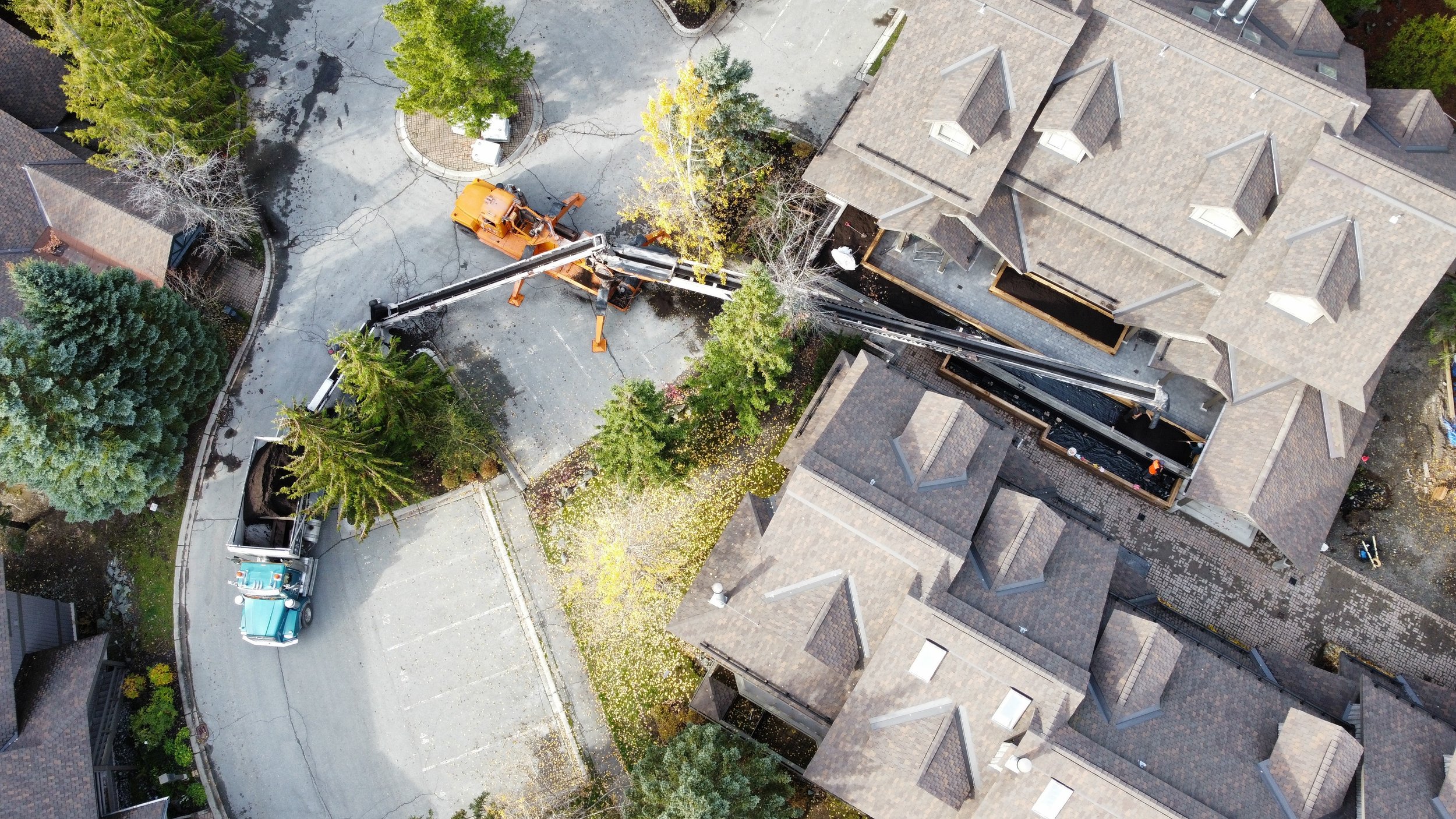 An aerial view of a residential property, material being delivered across difficult access area.