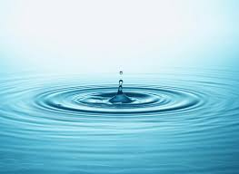 Single water droplet forming gentle ripples, symbolizing small changes creating meaningful impact.
