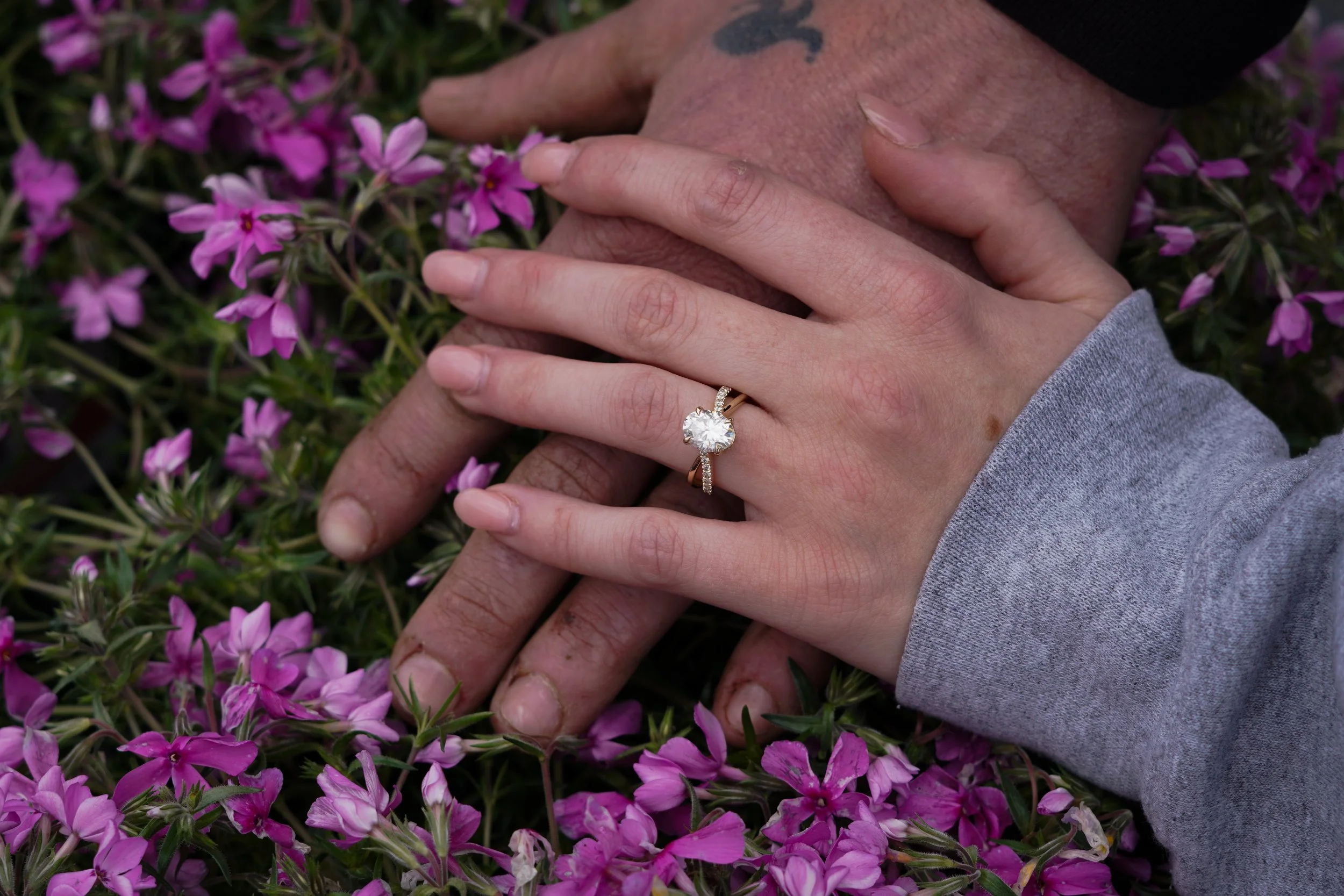 Two hands, one with a wedding ring, rest on pink flowers. Northern nj cheap engagement photos