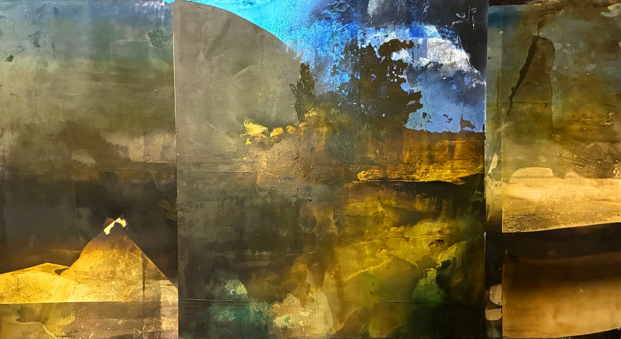Abstract painting reminiscent of natural vistas in golds, crisp blues, black and muted greysa nd greens