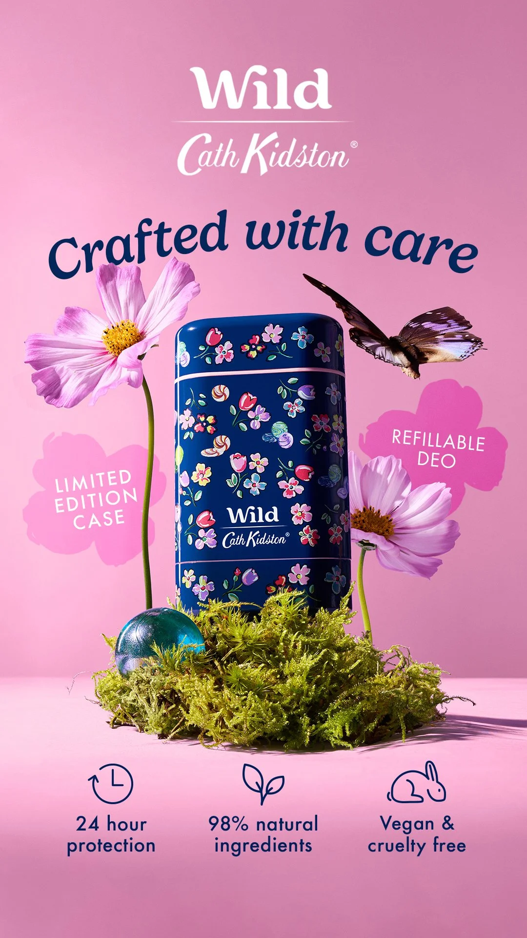 Product packaging for Wild Cath Kidston crafted with care deodorant, featuring a dark blue case with floral designs, pink flowers, a butterfly, a decorative green moss, and icons indicating 24-hour protection, 98% natural ingredients, and vegan cruelty-free formulation.