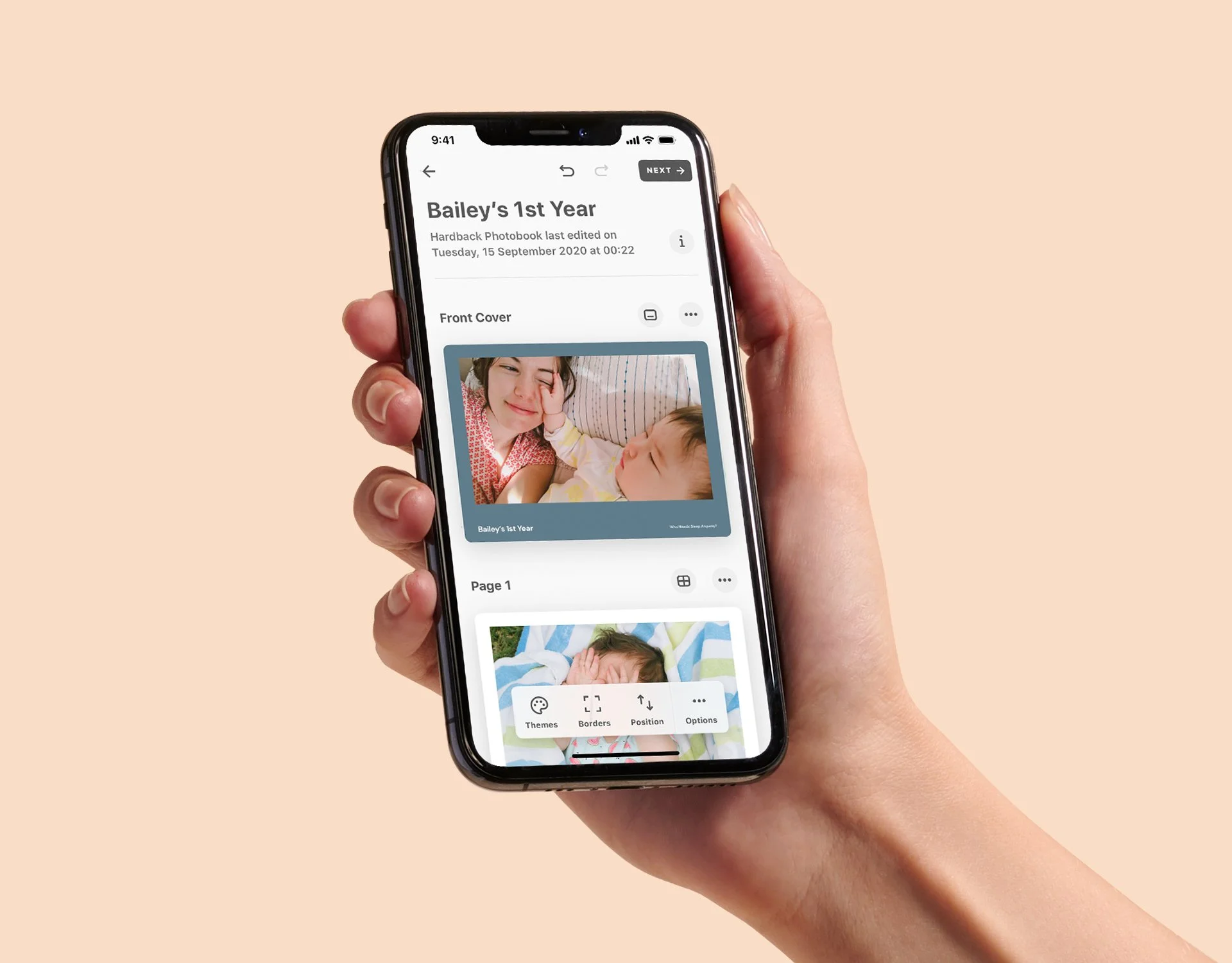 Close-up of a hand holding a smartphone displaying a photo album titled "Bailey's 1st Year," showing pictures of a young girl and a baby, with editing options at the bottom of the screen.