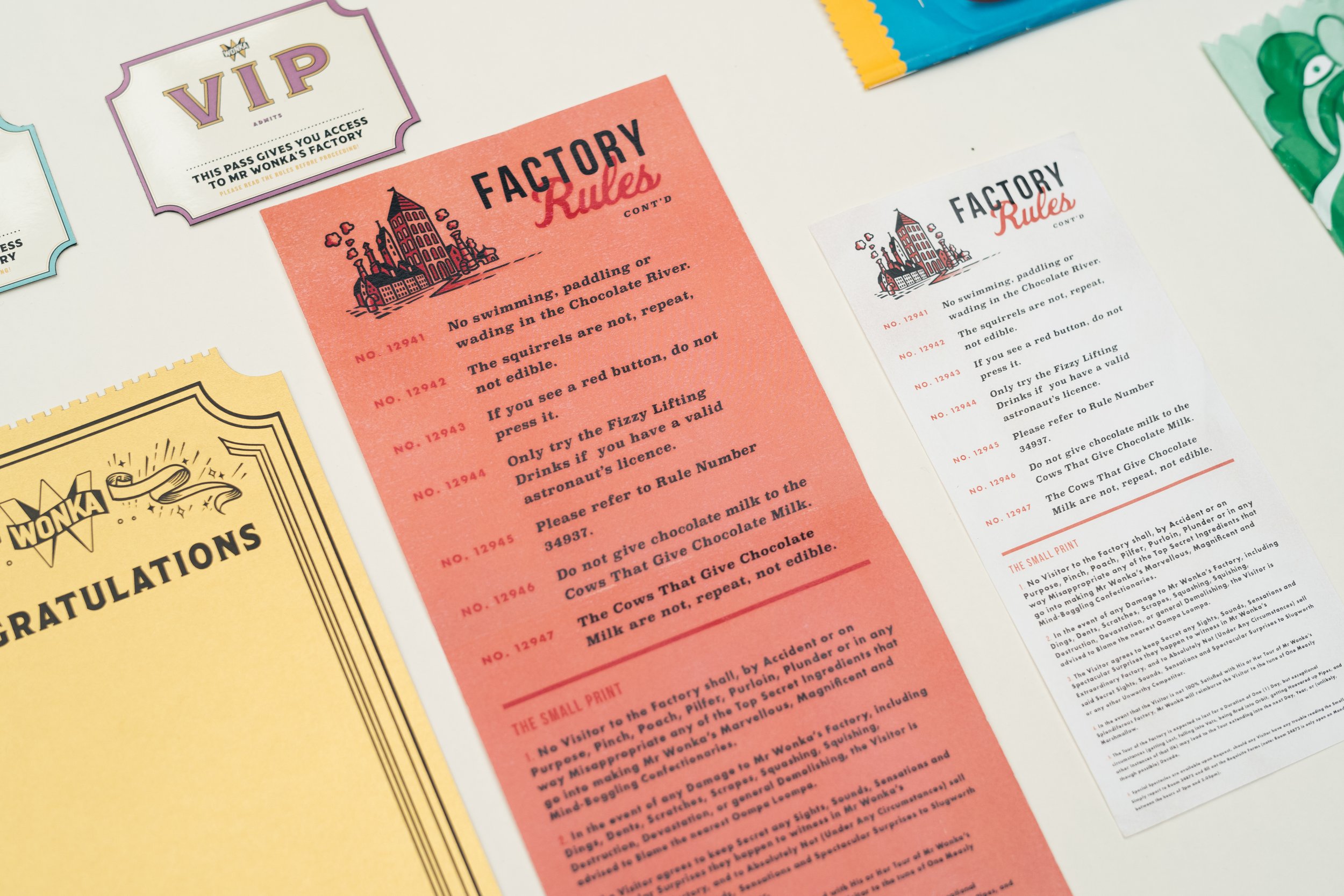 Several colorful play or themed passes and rules sheets laid out on a white surface, including a VIP pass, and various instructions with illustrations.