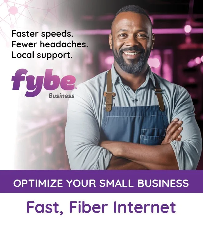 A smiling man with a beard wearing a gray shirt and a blue apron standing in a business setting with pink and purple lighting. The image promotes fast fiber internet for small businesses with text emphasizing faster speeds, fewer headaches, and local support.