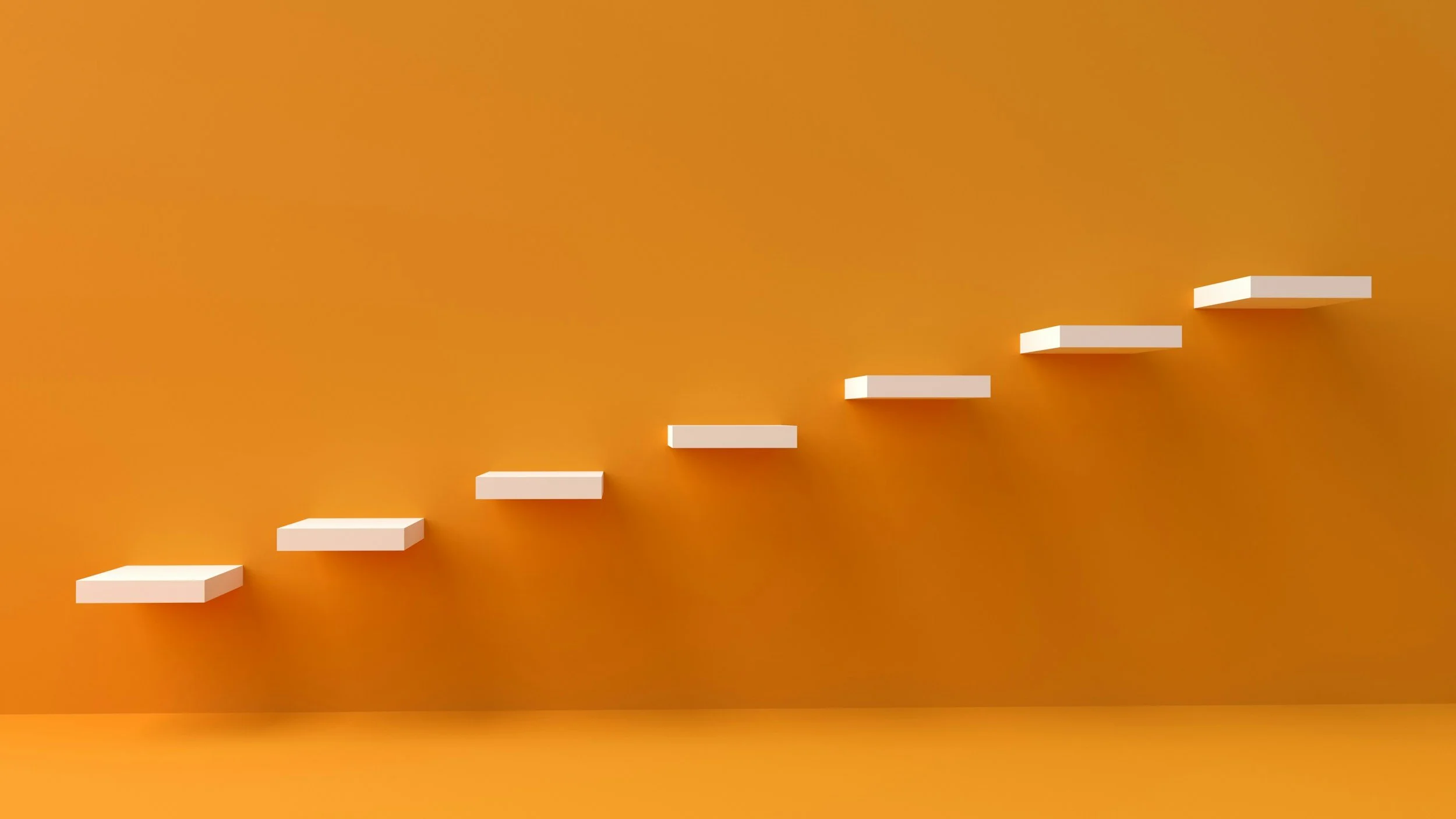 White floating shelves ascending diagonally on an orange wall.