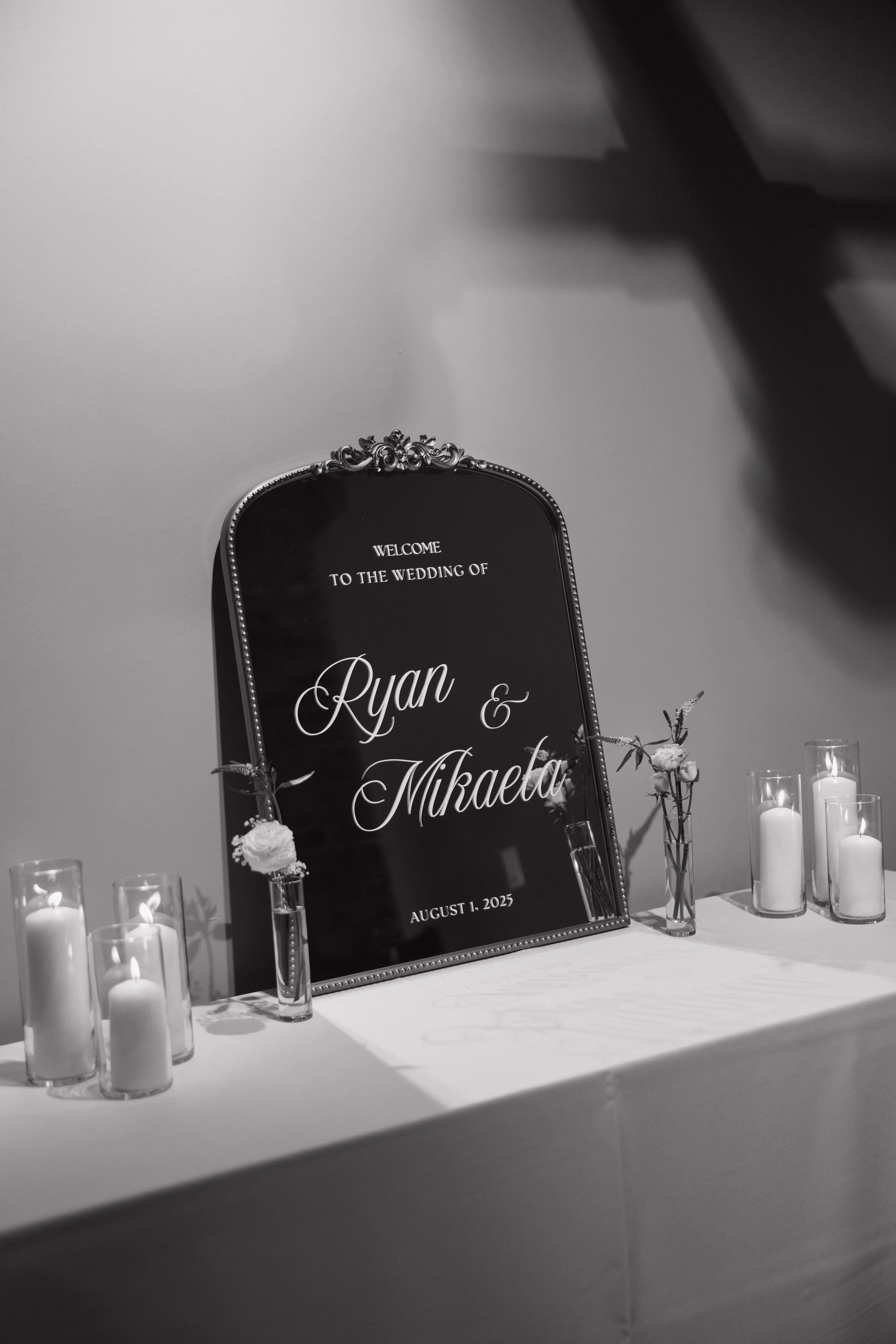 A welcoming entry table with a directional sign, delicate floral vases, and glowing candles, the kind of thoughtful detail Palm Events & Rentals takes care of so nothing is overlooked.