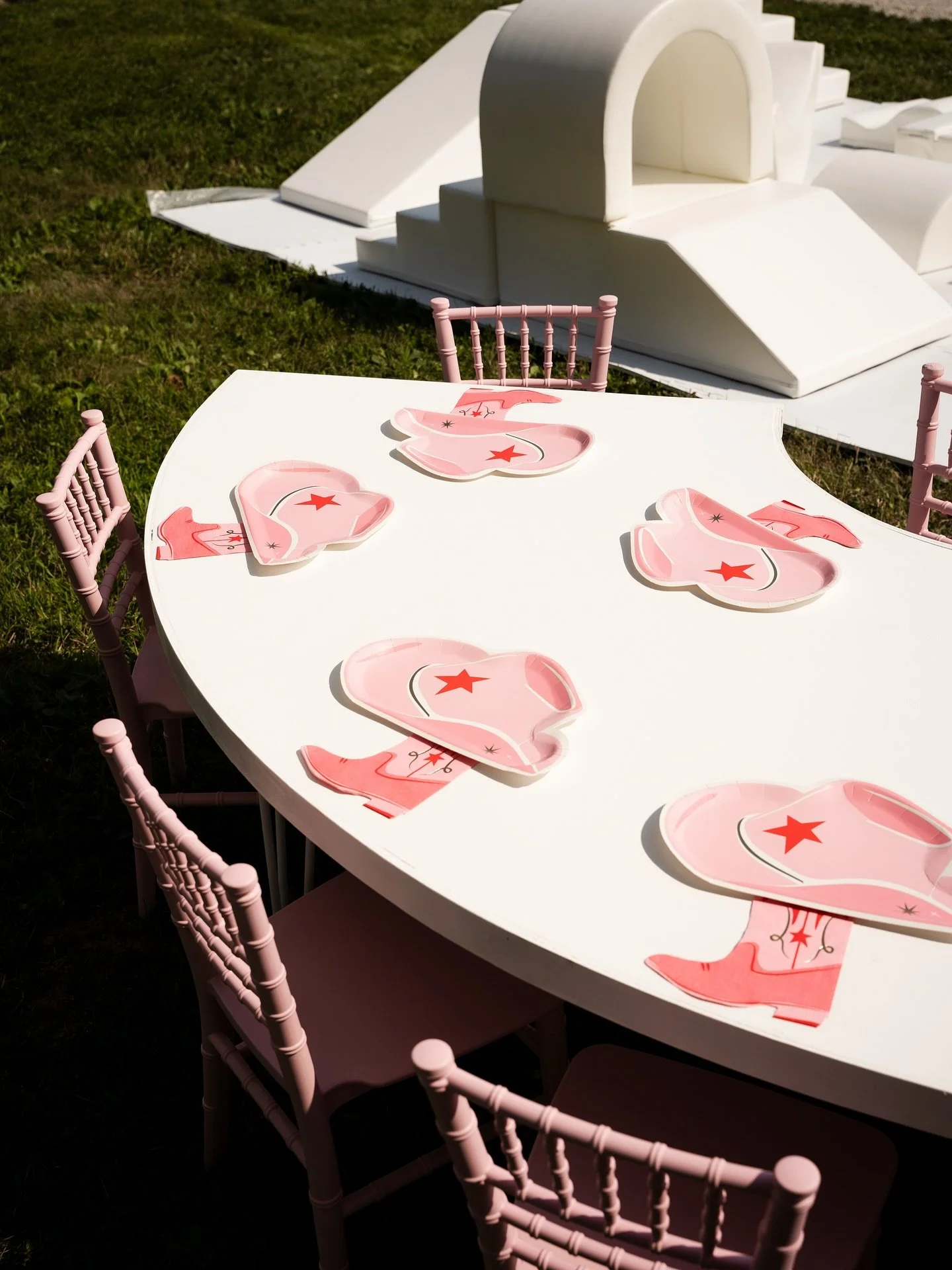 A charming outdoor kids' table with pink horse-shaped placemats and matching pink chairs, the kind of playful, perfectly styled touch Palm Events & Rentals brings to children's parties and family celebrations.