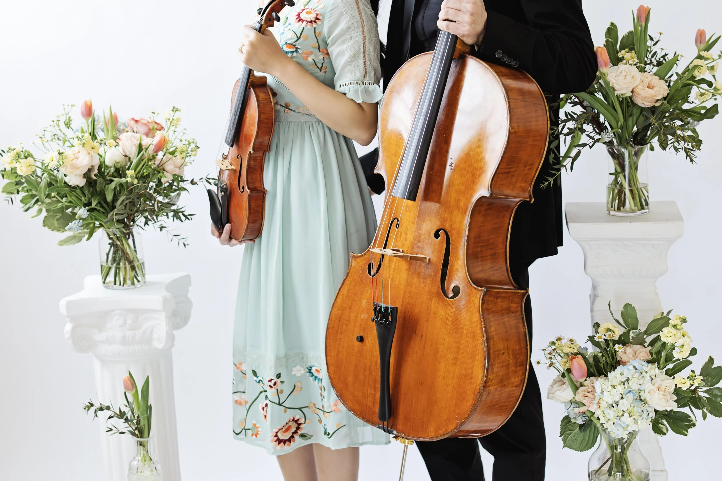 String duo surrounded by flowers