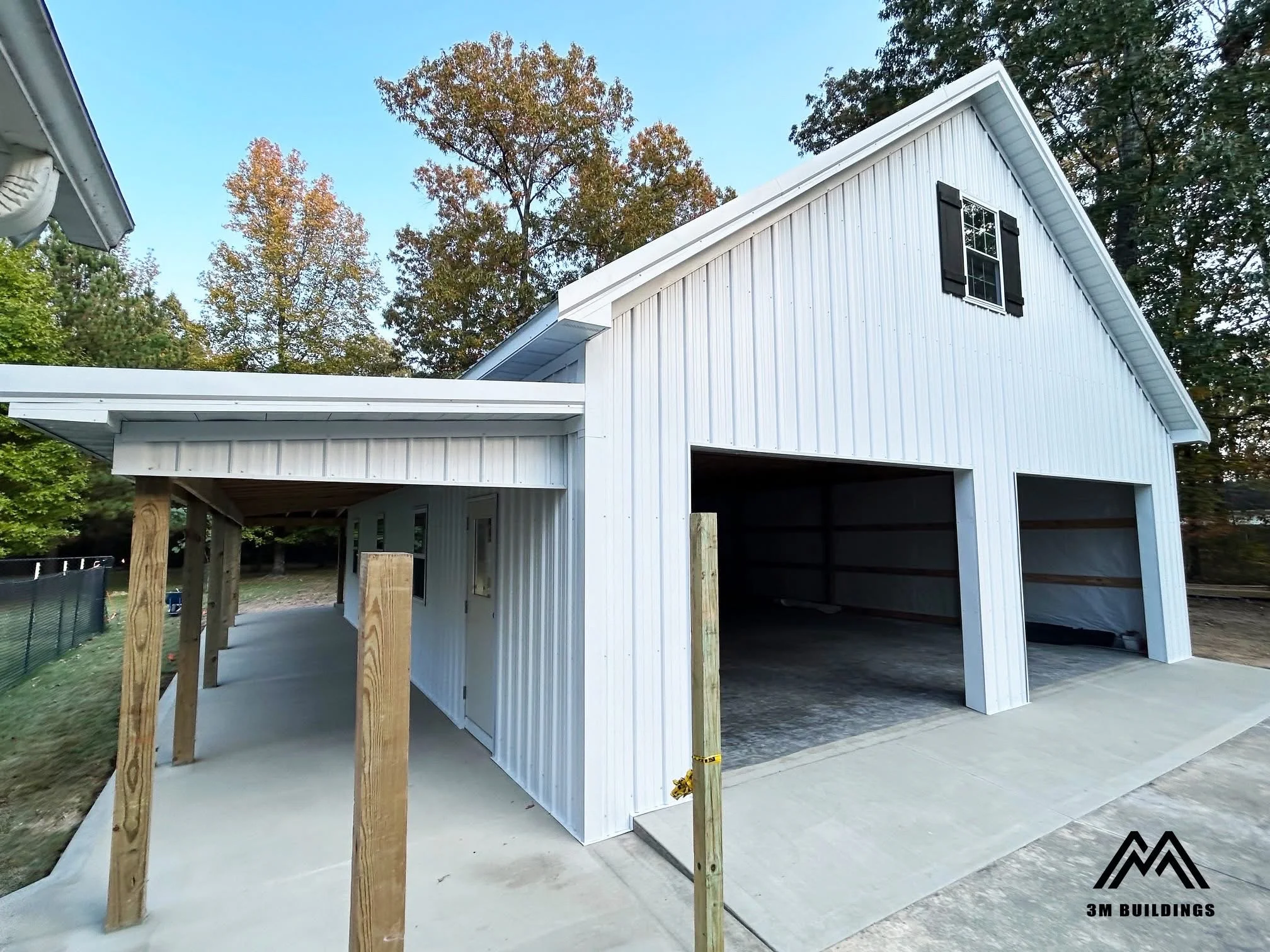 Custom 32x42x12 post-frame building with an 8-foot wrap around porch in Savannah, TN featuring White metal walls, White trim, and a Charcoal Gray roof, built by 3M Buildings.