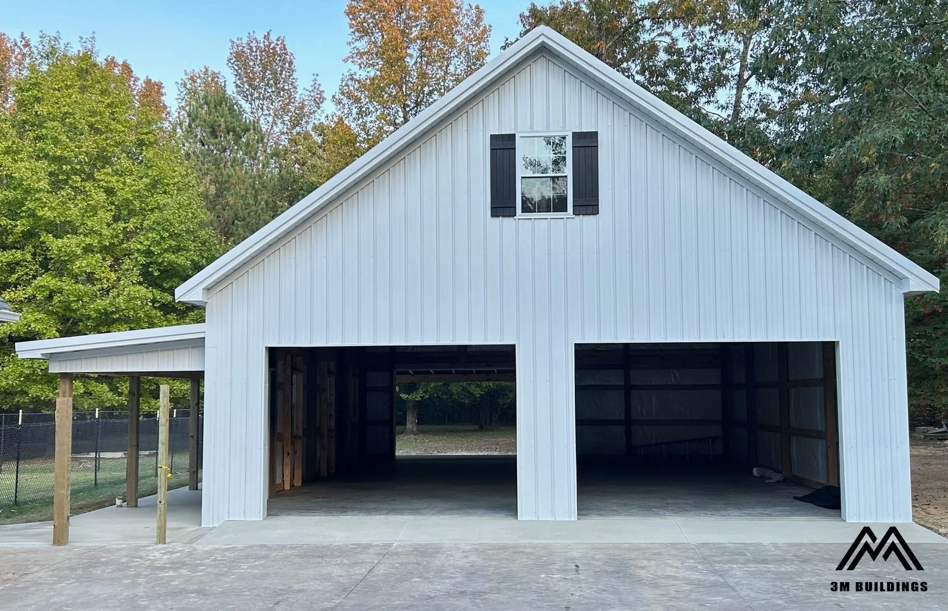 Custom 32x42x12 post-frame building with an 8-foot wrap around porch in Savannah, TN featuring White metal walls, White trim, and a Charcoal Gray roof, built by 3M Buildings.
