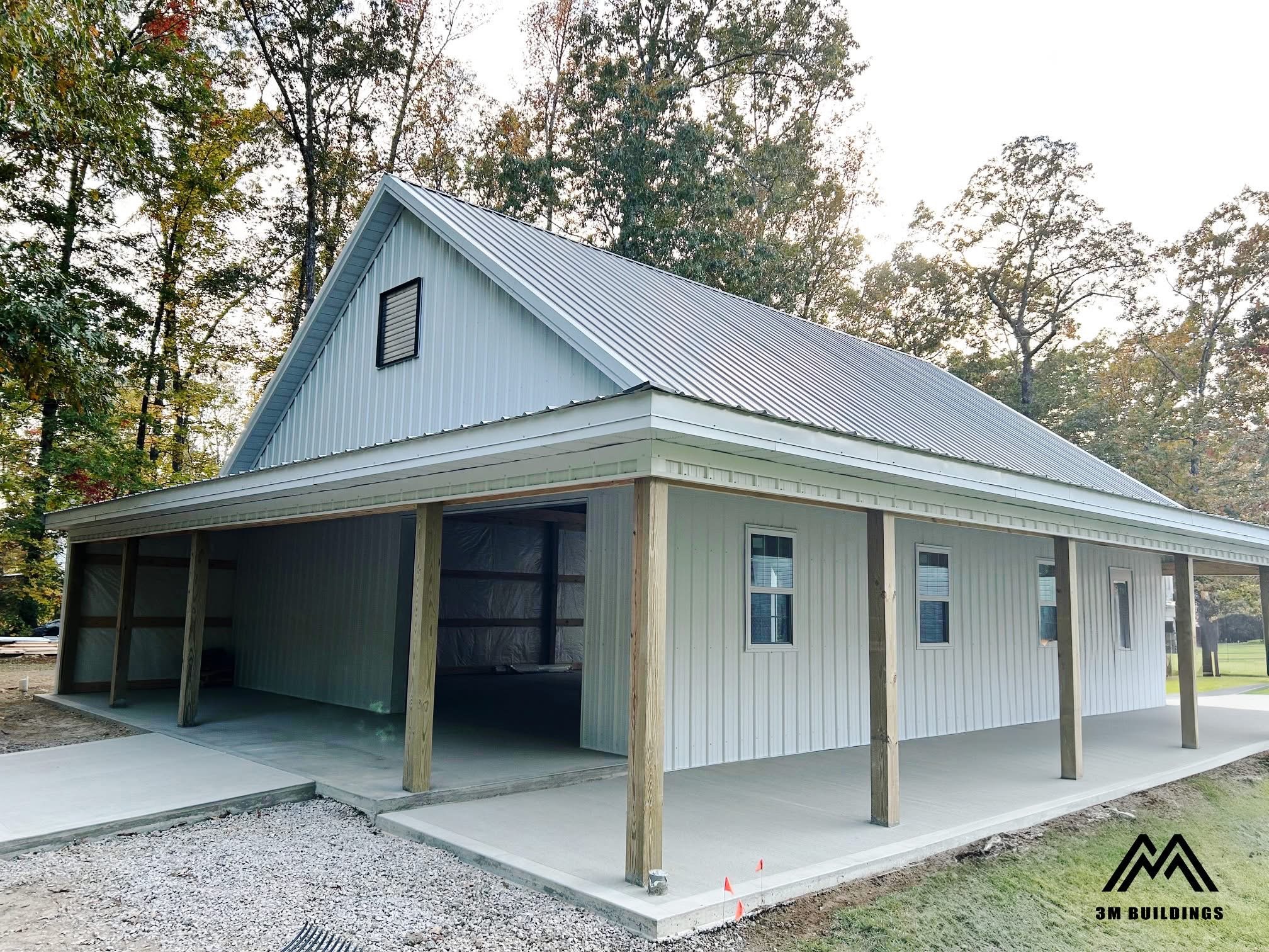 Custom 32x42x12 post-frame building with an 8-foot wrap around porch in Savannah, TN featuring White metal walls, White trim, and a Charcoal Gray roof, built by 3M Buildings.