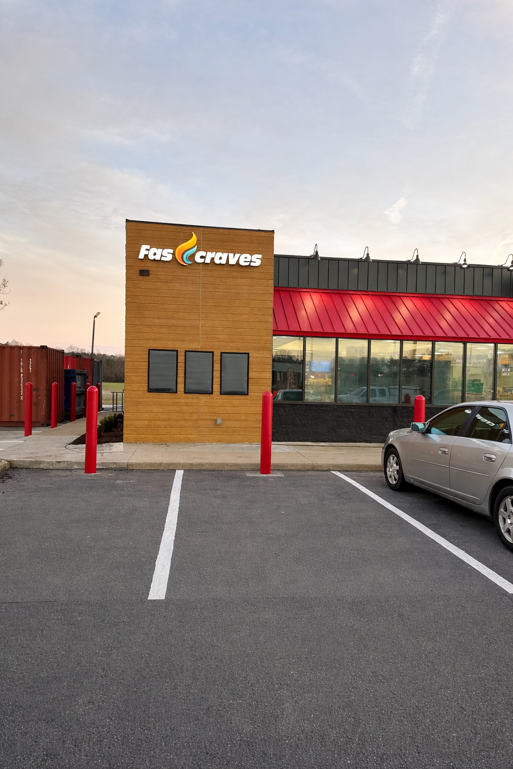Exterior of a Fas Craves / Fas Mart convenience store with parking spaces, a gray car, red bollards, a gas station, and a curved glass window.