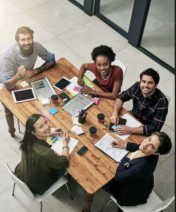 Five diverse creative adults discussing team dynamics and collaboration