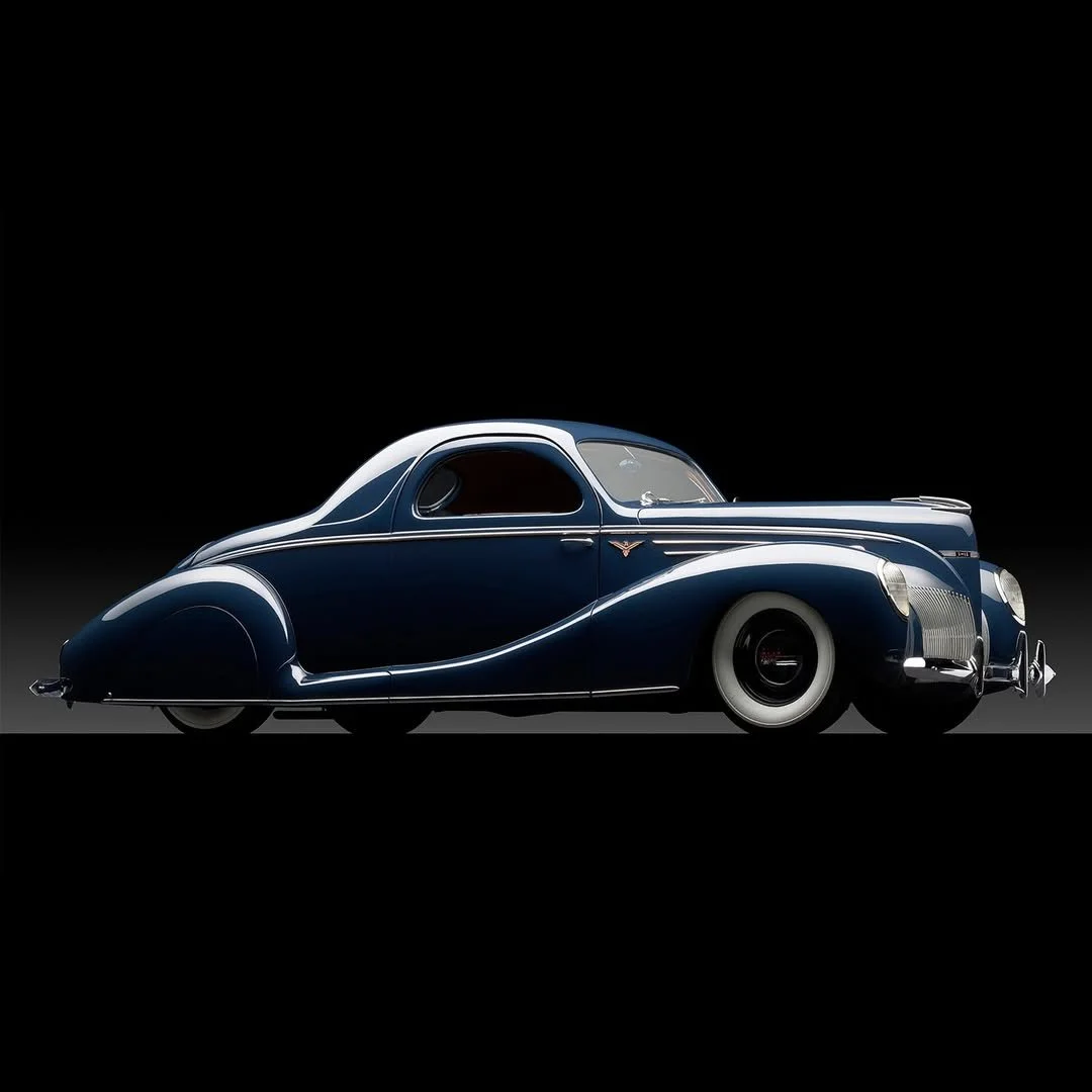 A vintage blue luxury car with whitewall tires displayed against a black background.