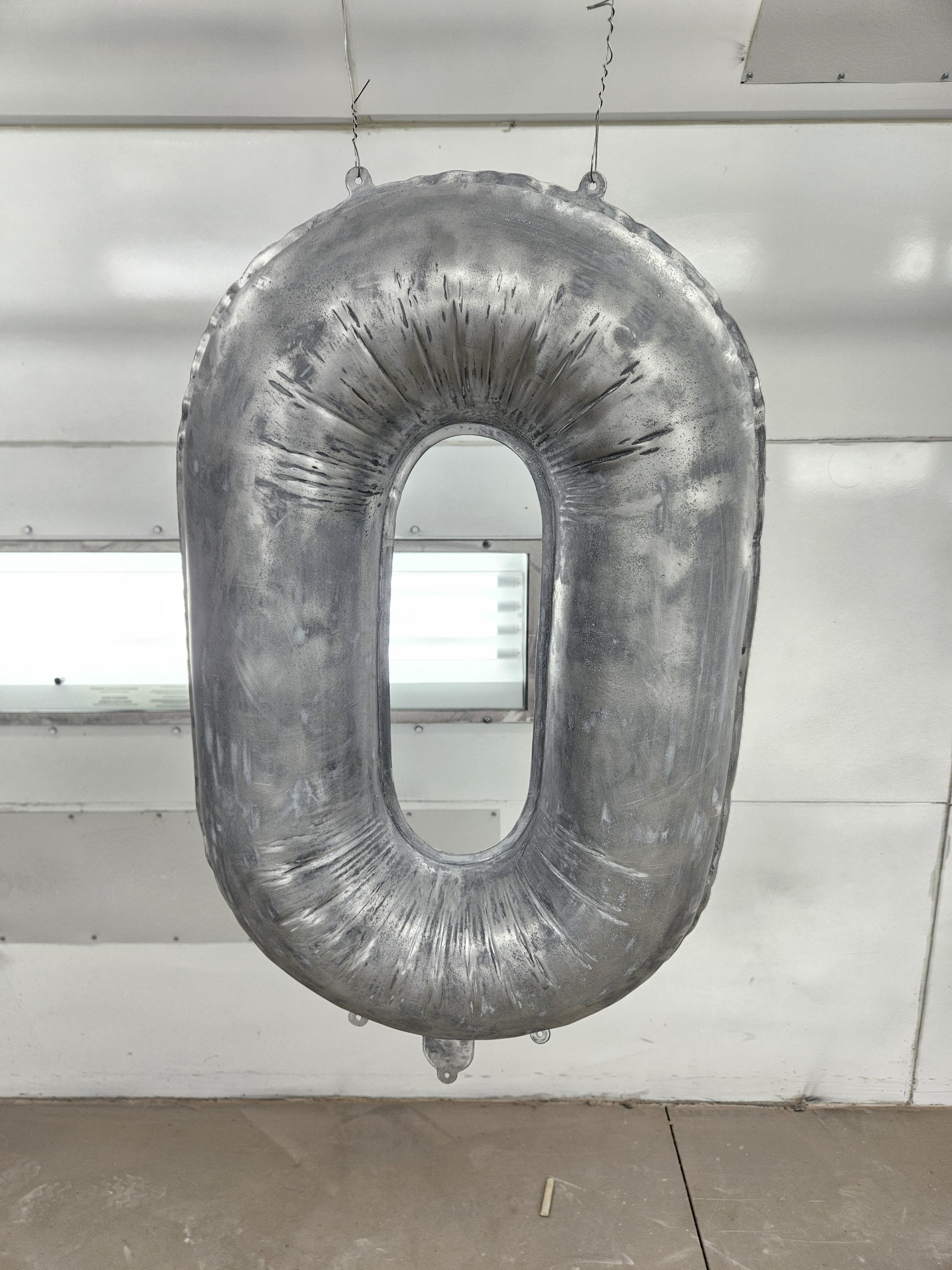 A metallic inflatable number zero hanging from the ceiling.
