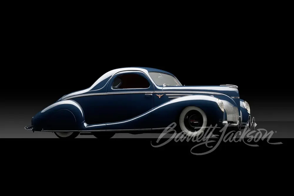 Vintage blue luxury car with streamlined design on a black background.