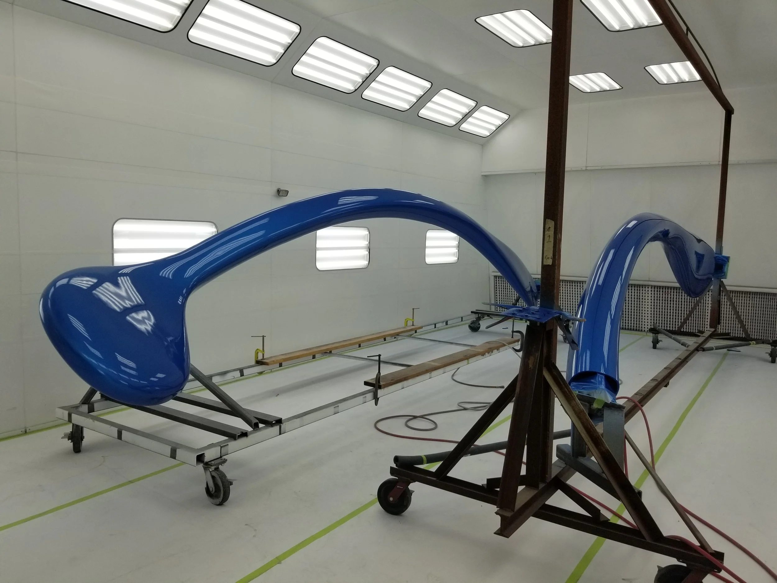 Large blue plastic tube in a clean room on a wheeled platform, possibly part of a scientific or industrial experiment.