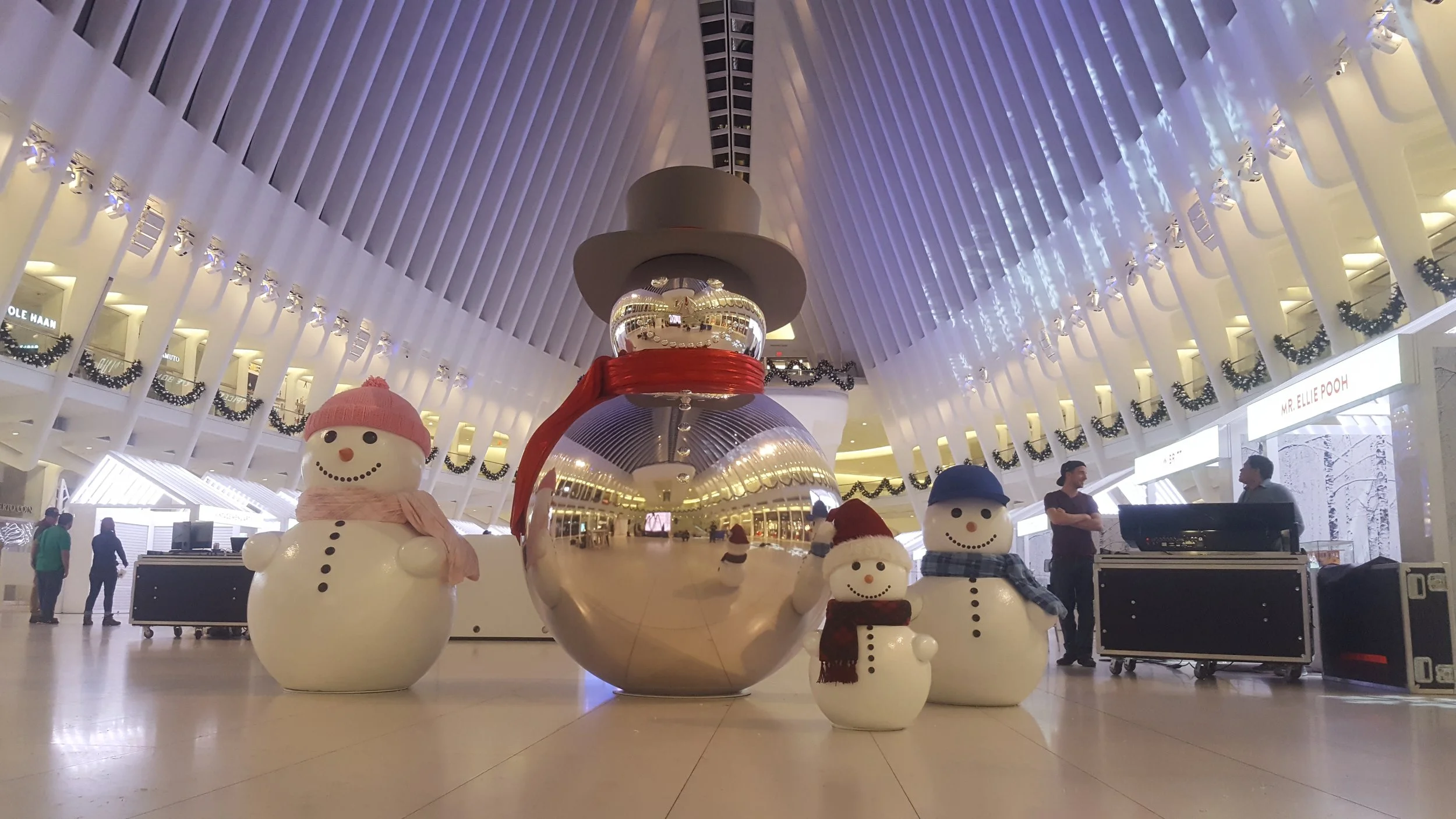 Large silver Christmas snowman and snowwoman sculptures, located at the Oculus in Manhattan.