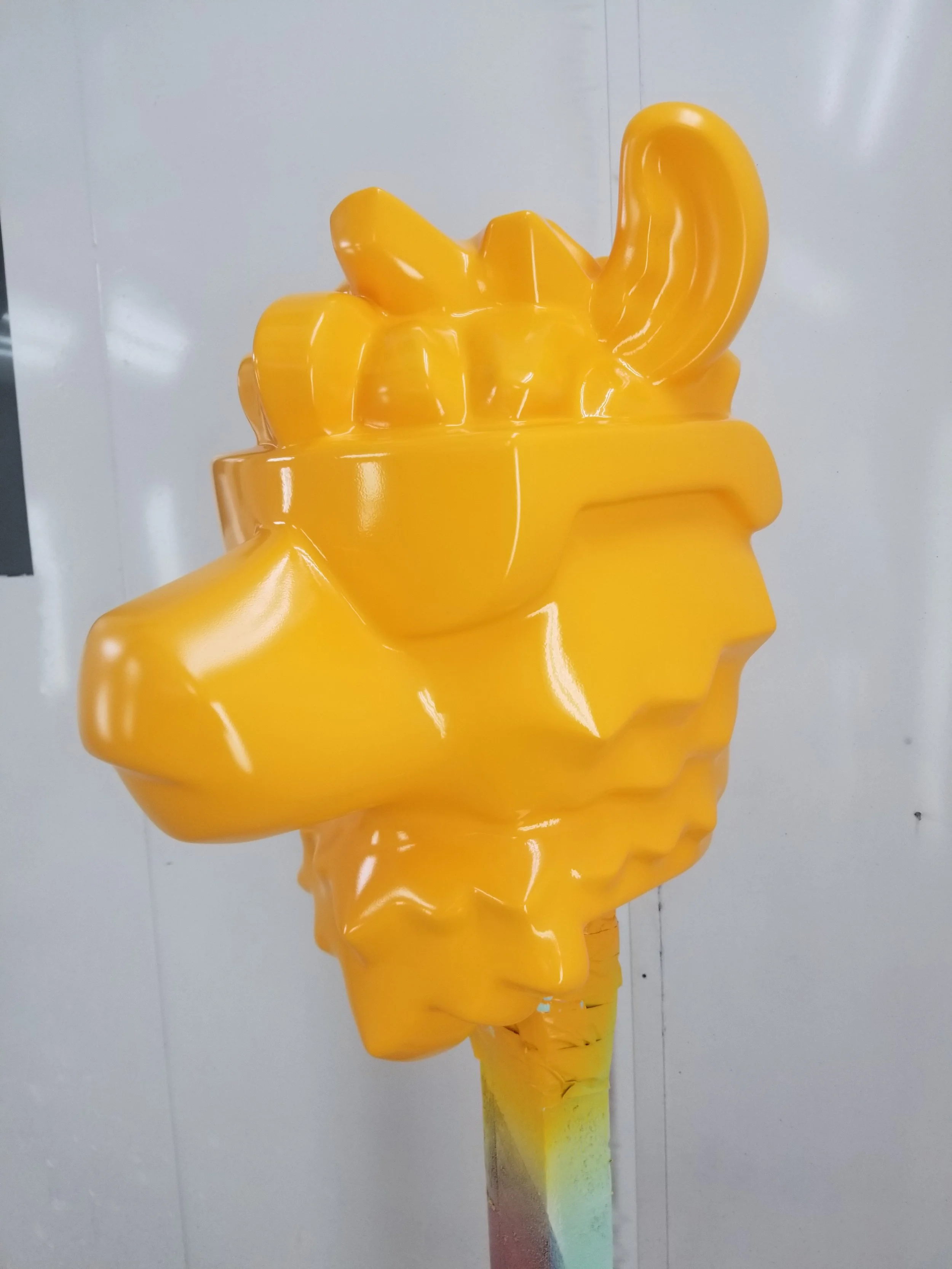 A bright yellow sculpture of a camel head 