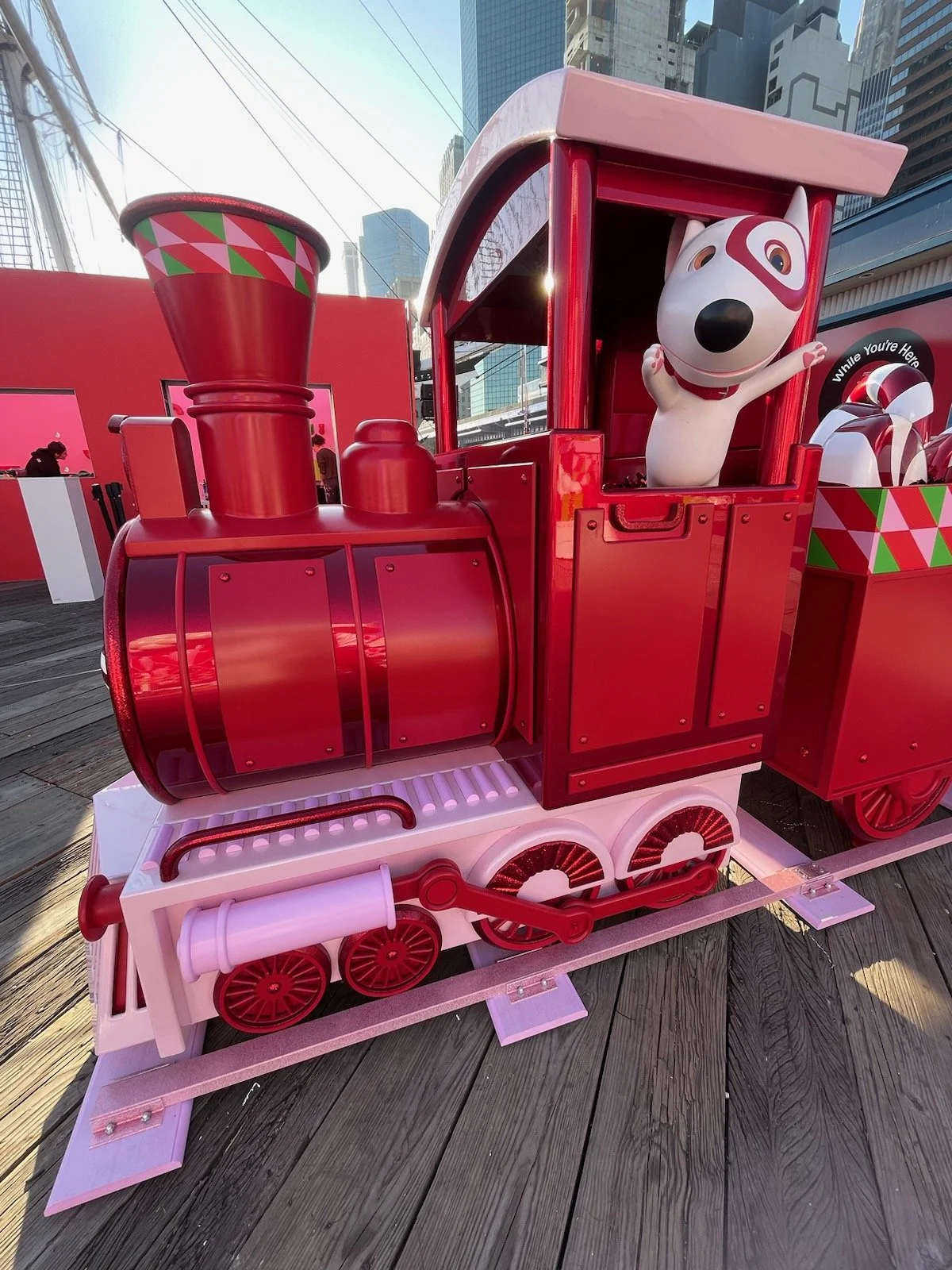 Red holiday-themed train with a cartoon dog character waving from the front.