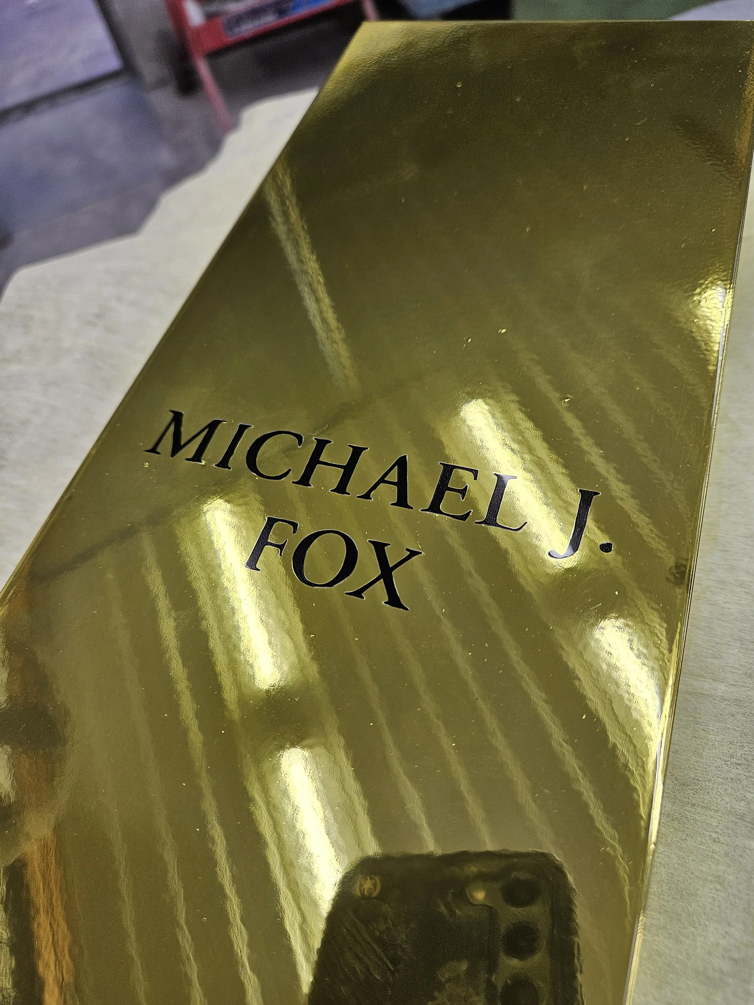 Gold-colored box with black text reading 'Michael J. Fox'.