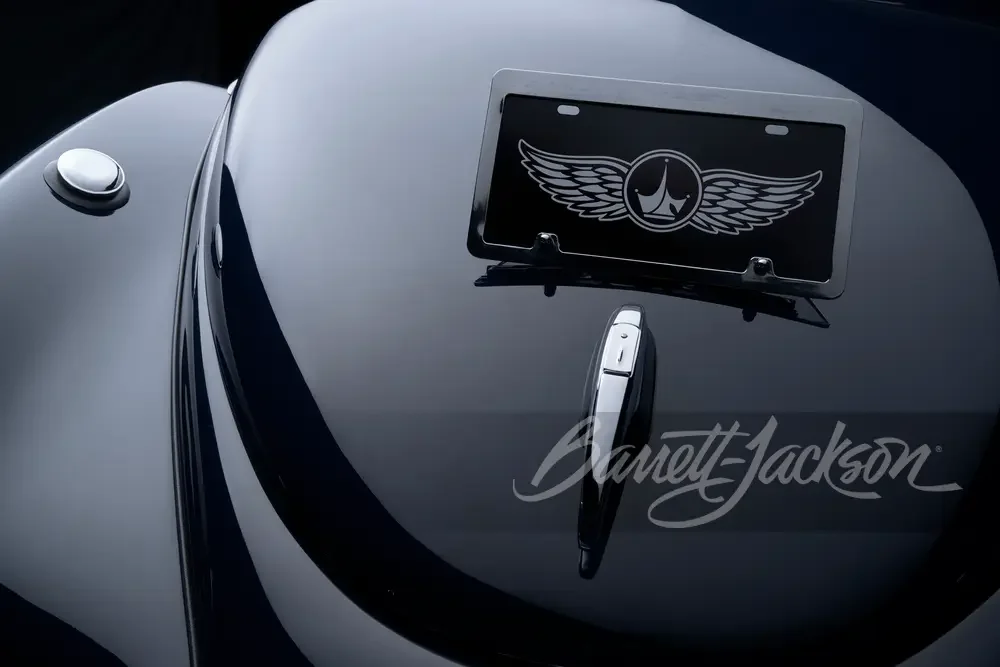 Close-up of a motorcycle's dashboard with a mounted tablet displaying a logo with wings and a teardrop shape in the center.