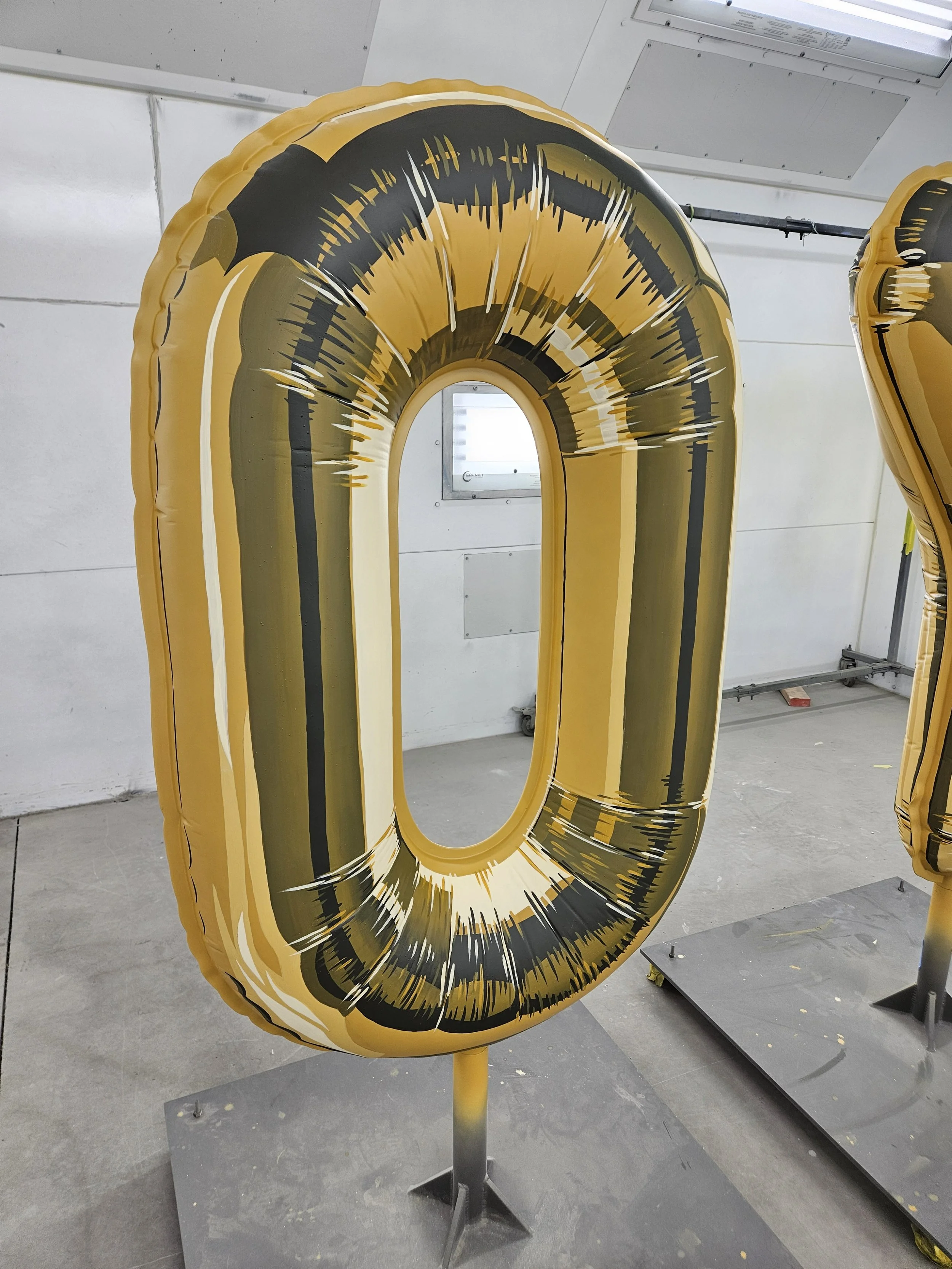Gold and black number 0 shaped balloon.