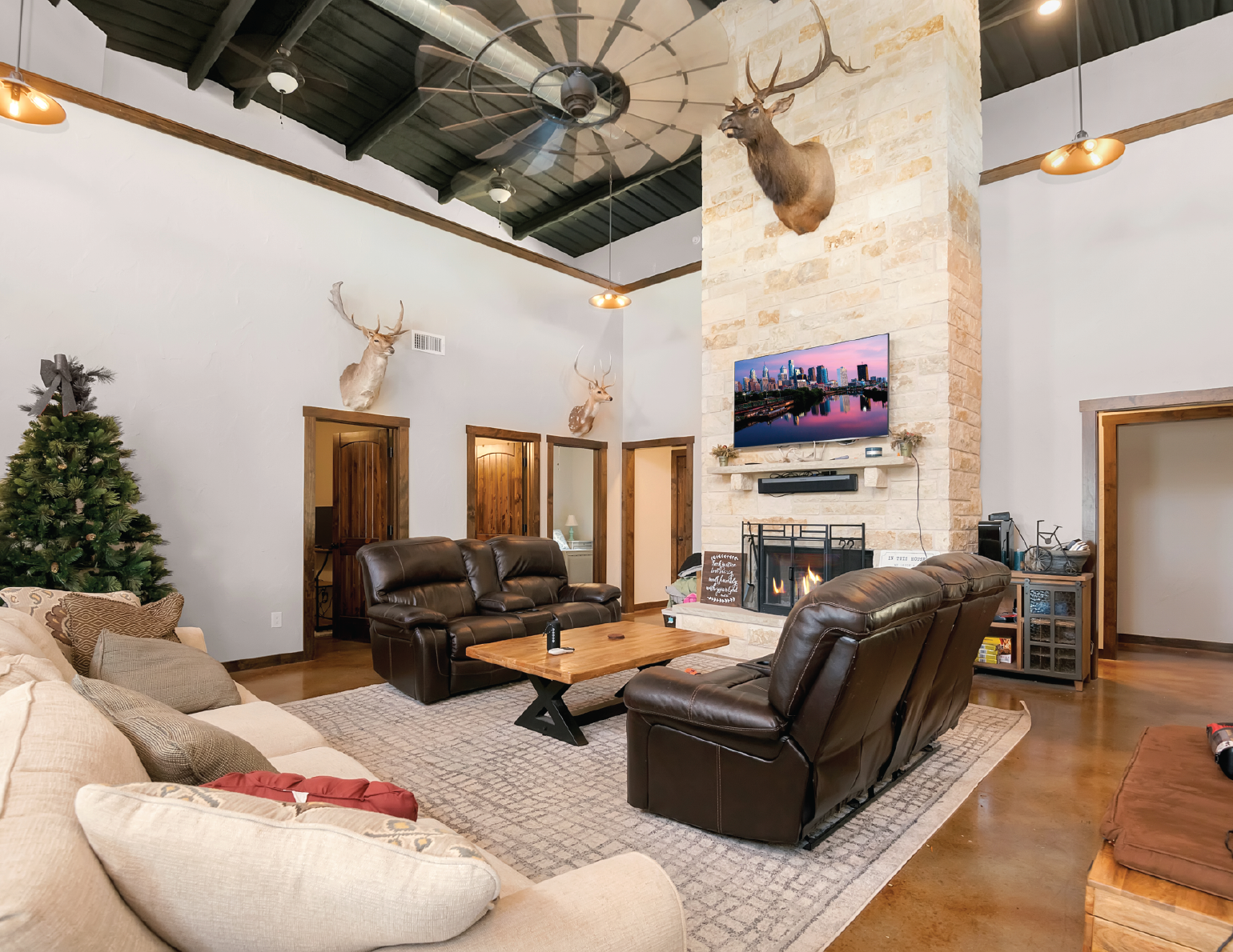 Custom living room with tall ceilings and grand stone fireplace