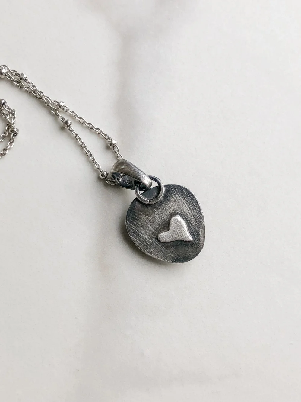 Heart detail on the back of the silver pendant
