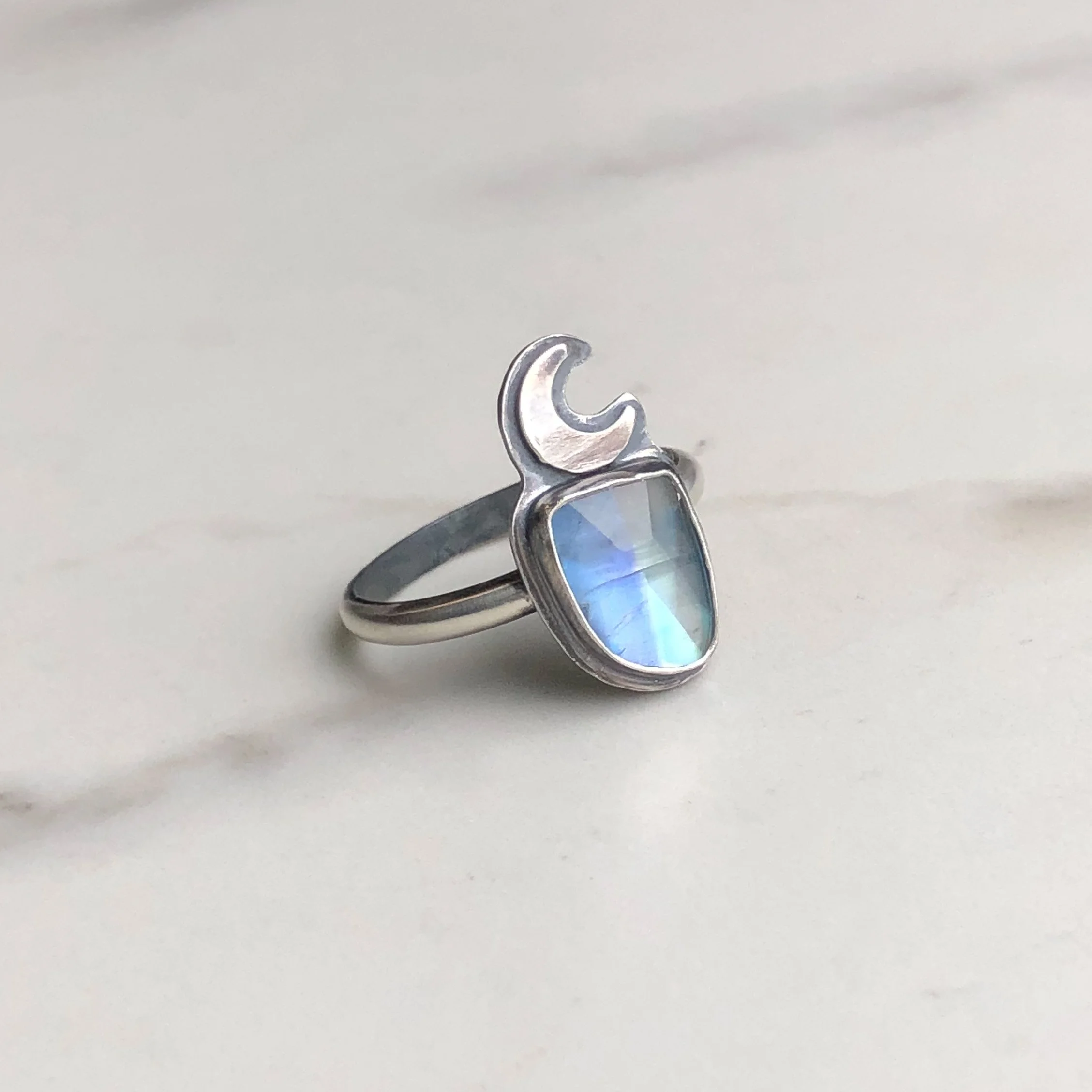 Moonstone ring with a silver crescent accent