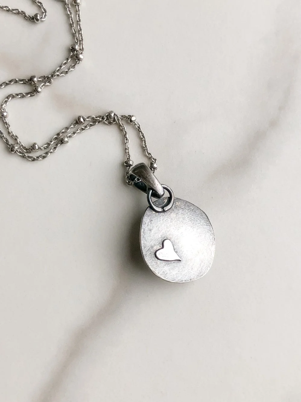 Heart detail on the back of the silver pendant