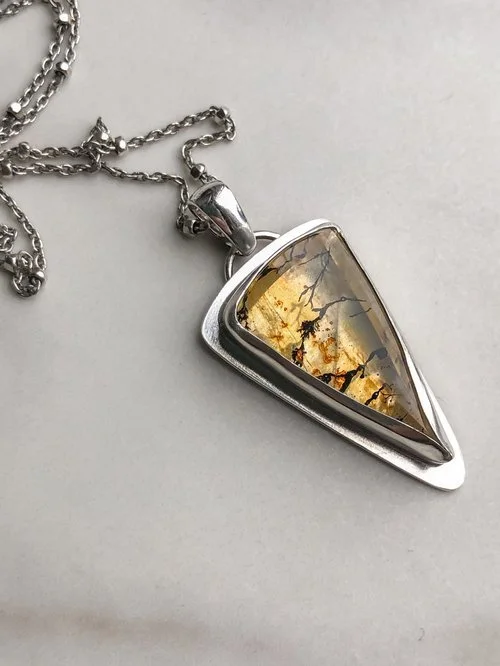 I love this stone!! This glowy yellow color in stone is due to iron oxides that lie within. Breanch-like dendrite inclusions can be seen across this Quartz stone. The chain features tiny faceted beads.