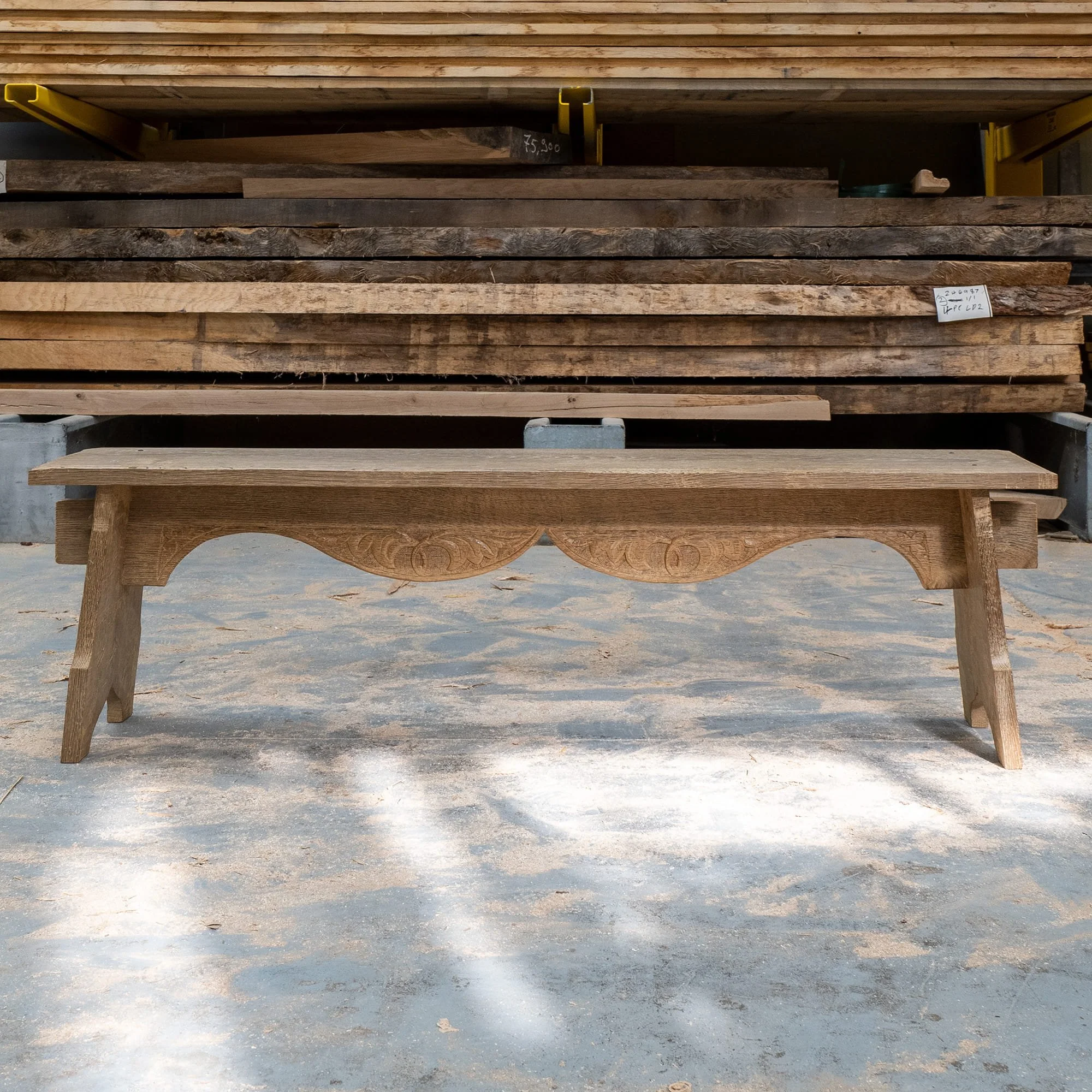 Stacked wooden planks on a metal rack in a workshop or lumber yard.