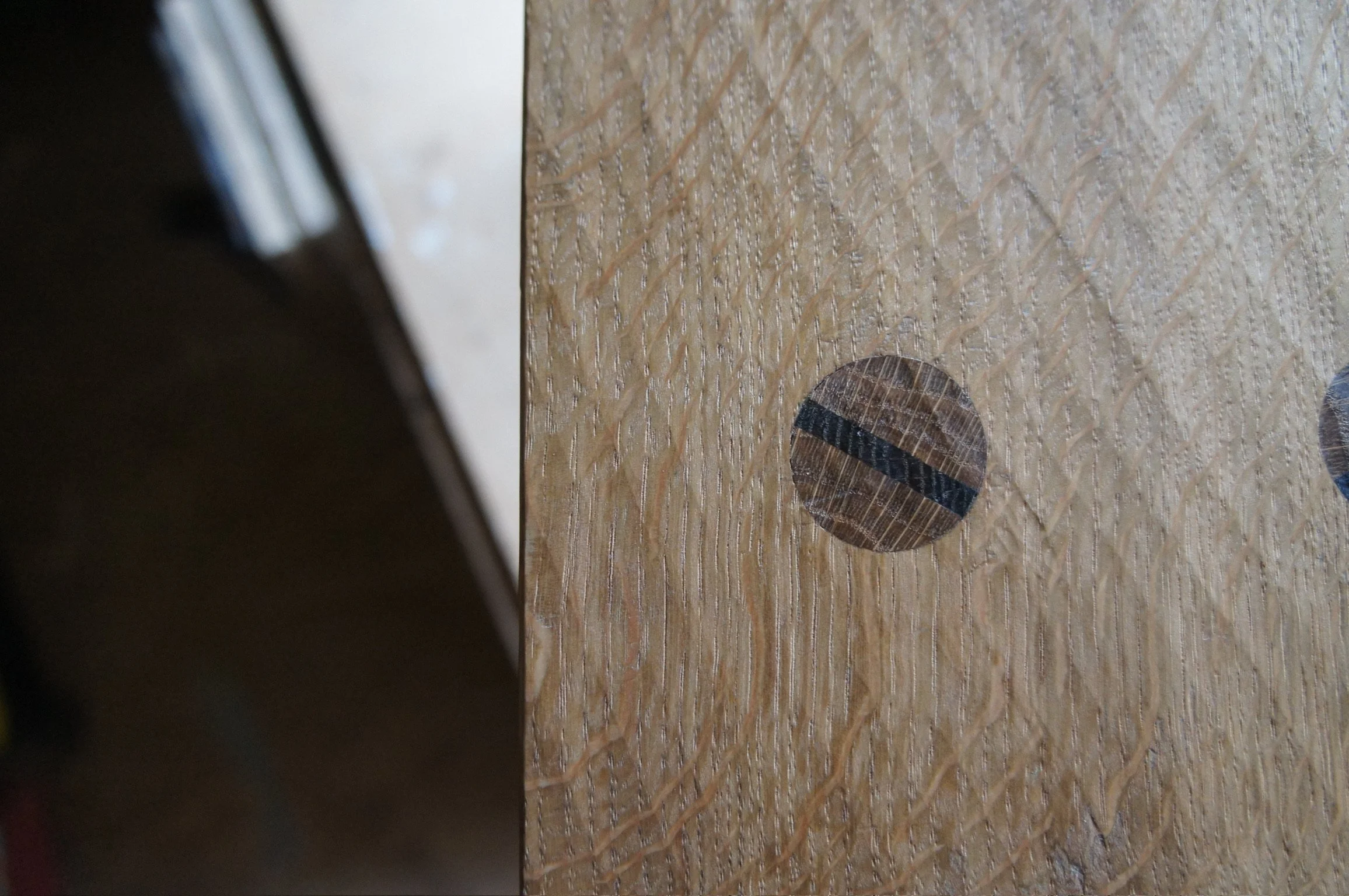 Close-up of a section of textured wooden surface with contrasting wedged tenon.